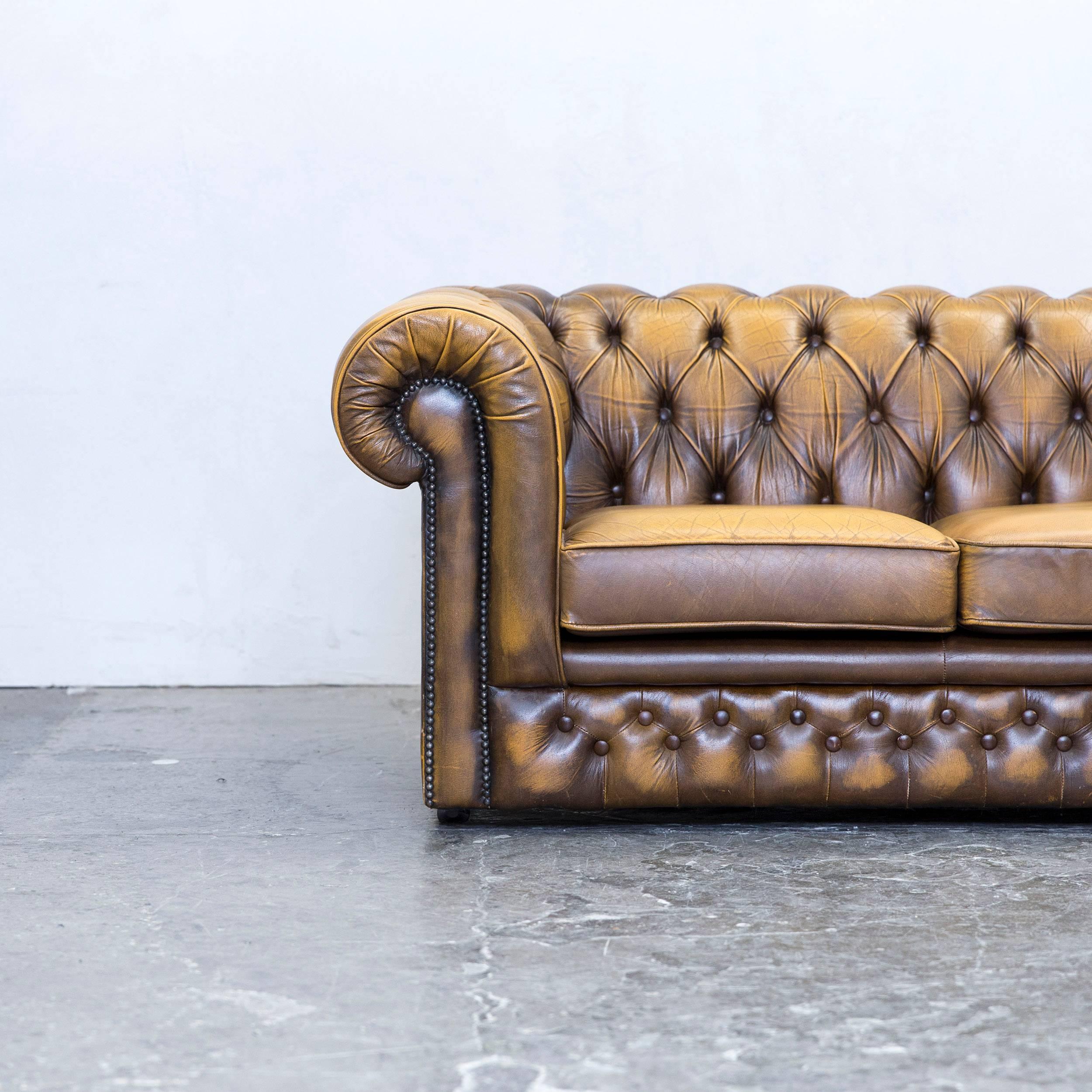 Brown colored original Thomas Lloyd Chesterfield leather sofa in a vintage design, made for pure comfort and elegance.