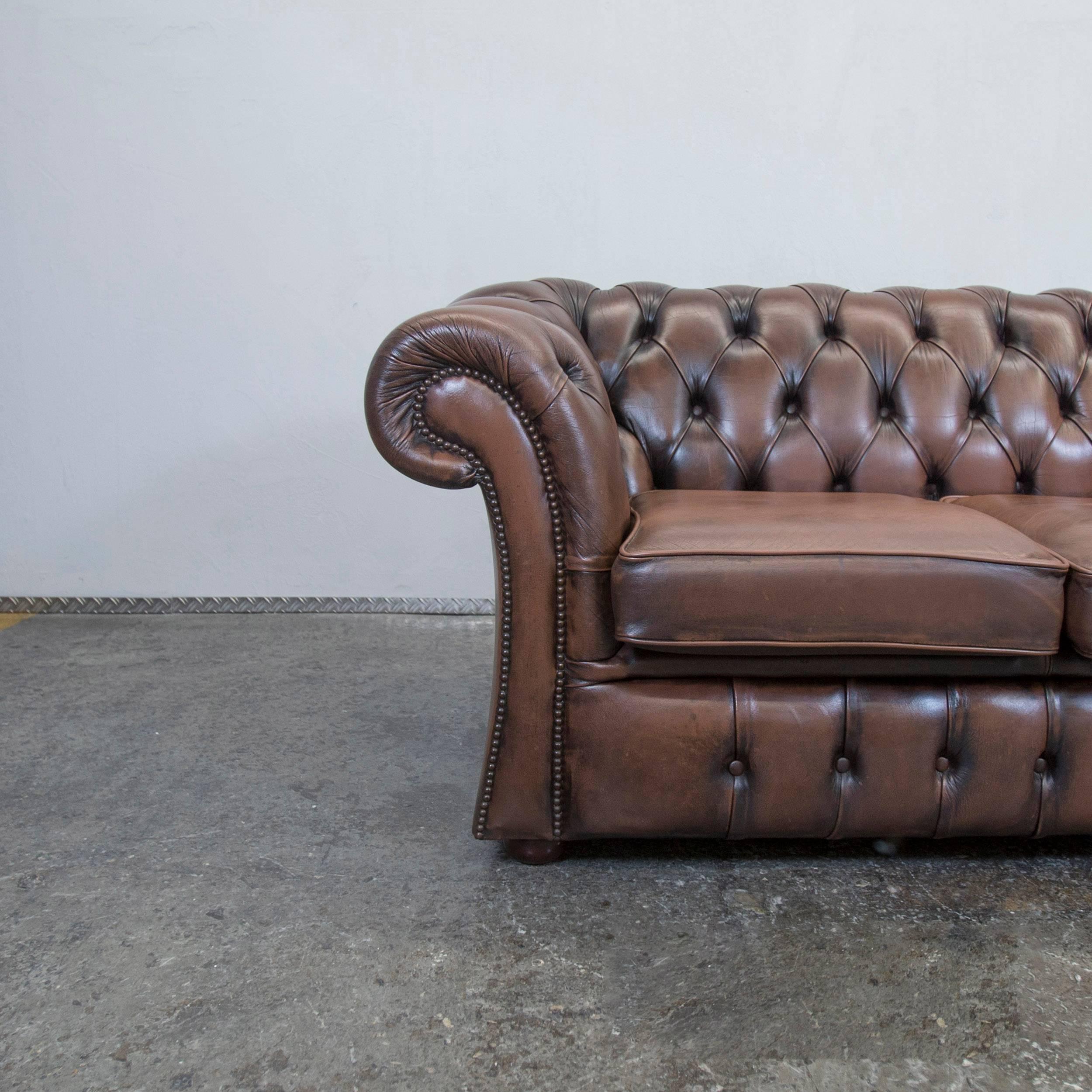 Brown colored original Chesterfield leather sofa in a vintage design, made for pure comfort and elegance.