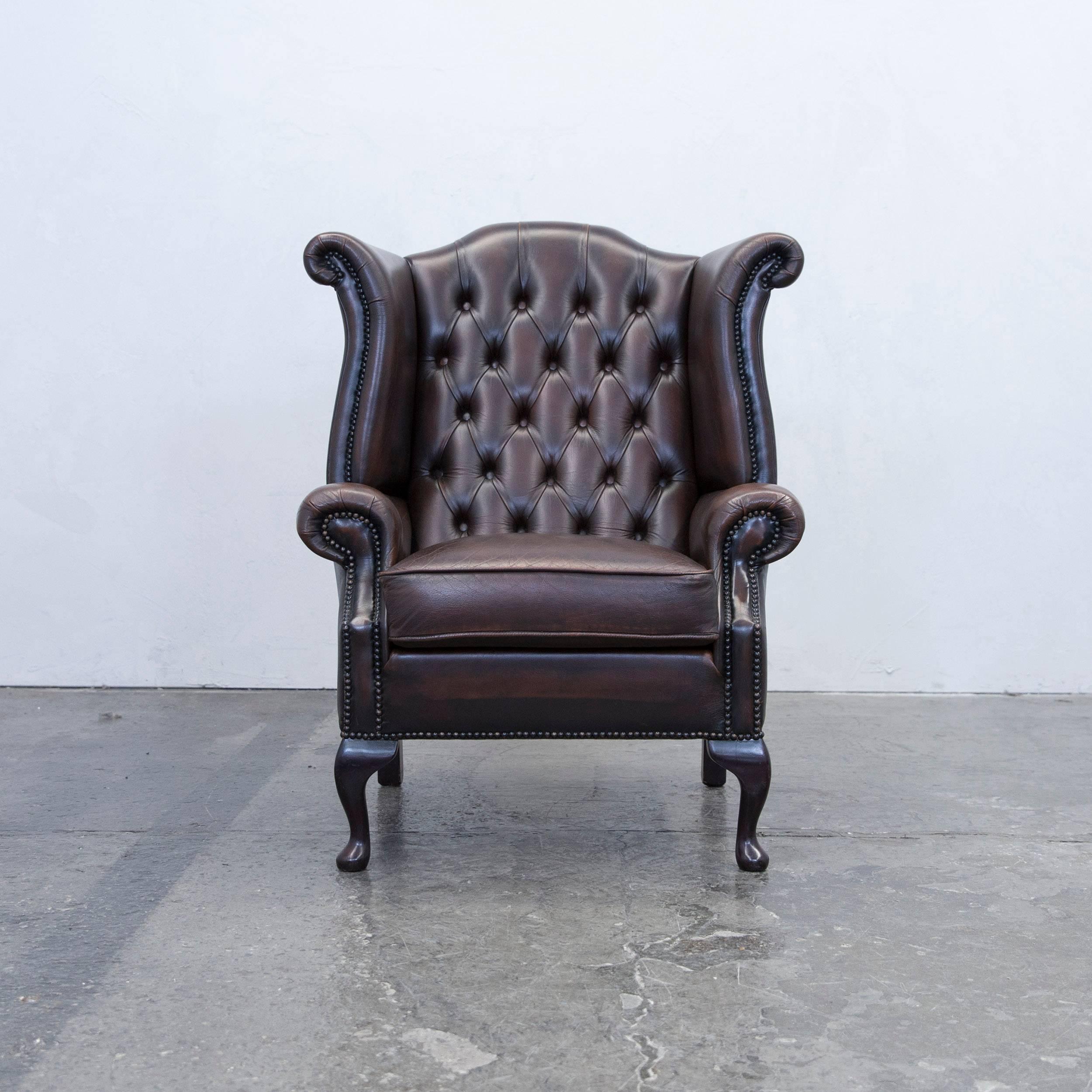 Brown colored original Chesterfield leather wingback chair in a vintage design, made for pure comfort and elegance.