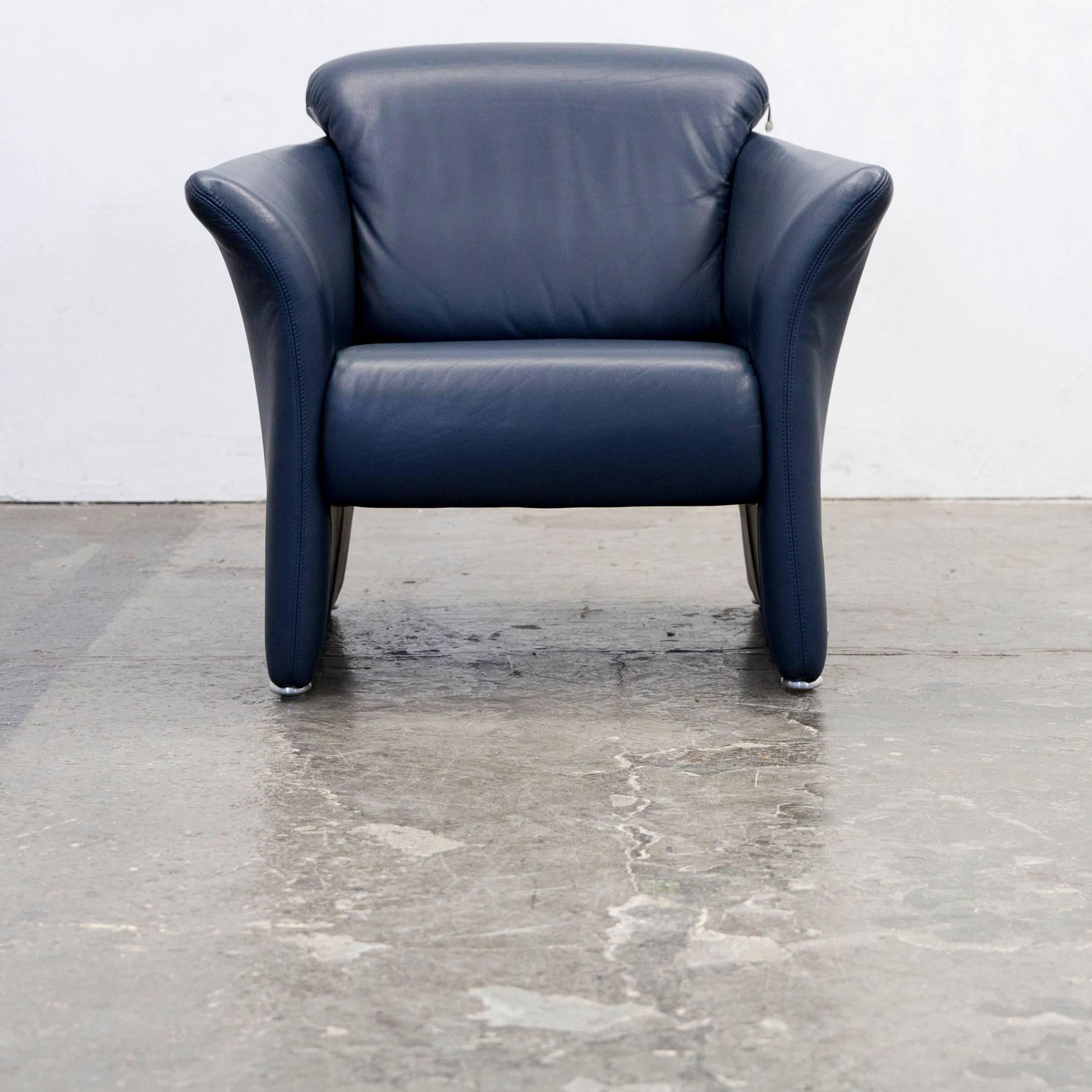 Blue colored original Koinor designer leather armchair in a minimalistic and modern design, made for pure comfort and style.