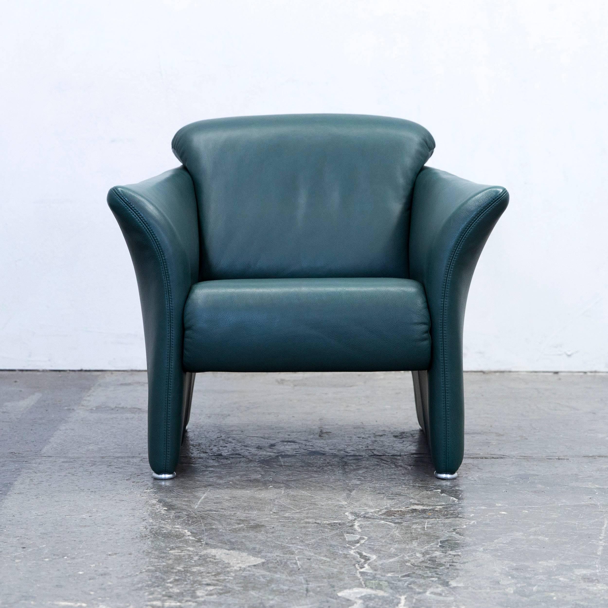 Green colored original Koinor designer leather armchair, in a minimalistic and modern design, made for pure comfort and style.