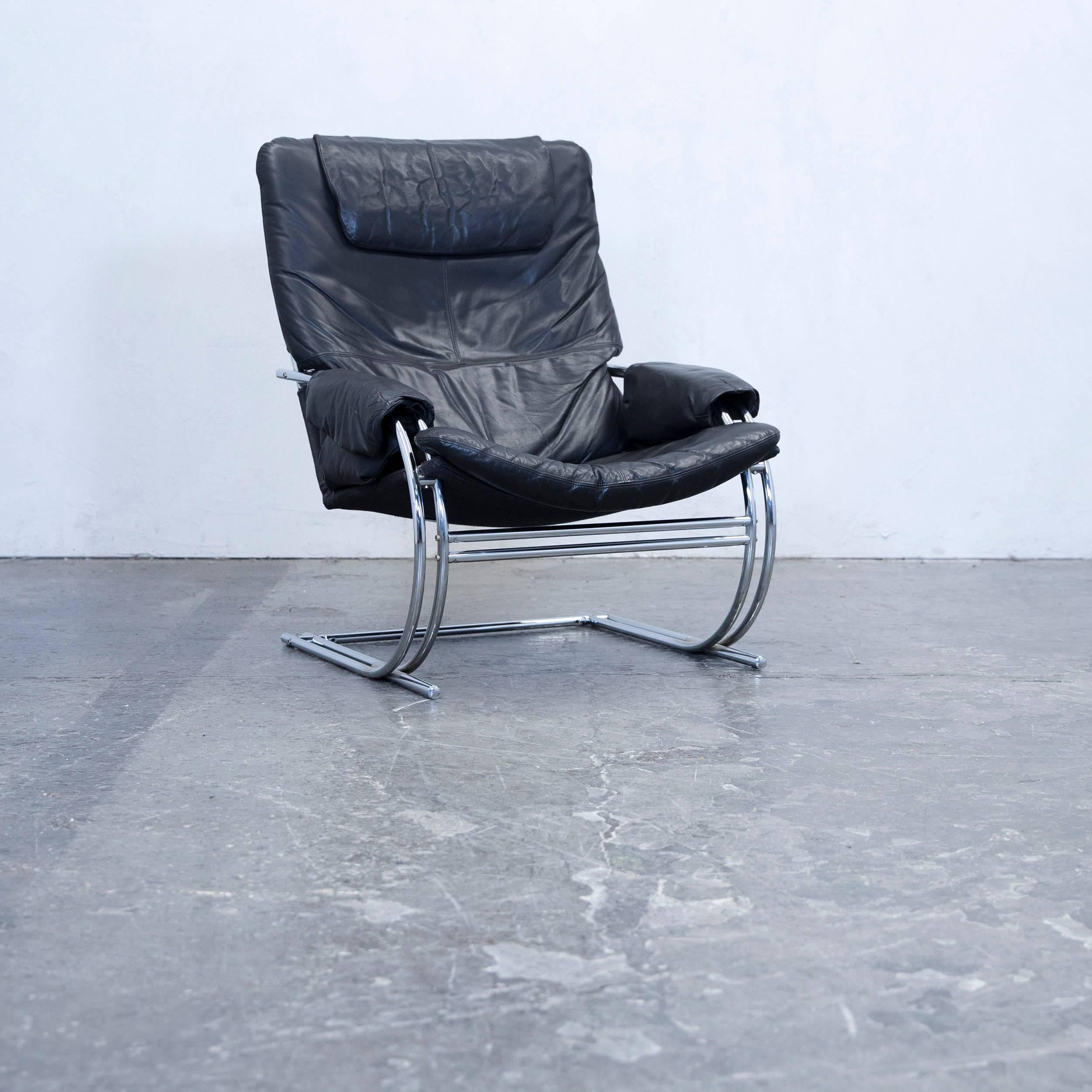 Black colored designer armchair and footstool in a modern design, made for pure comfort.