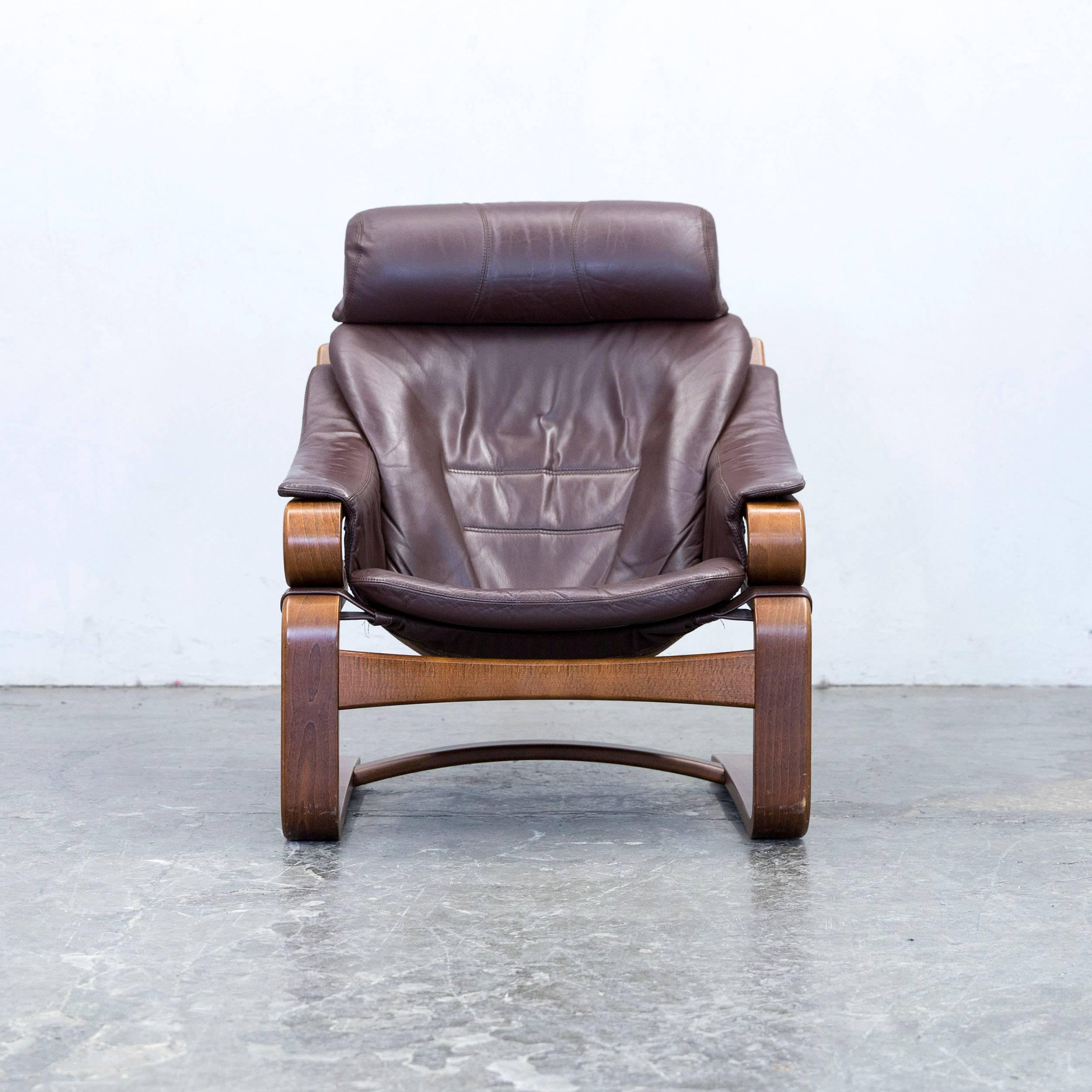 Brown colored designer leather armchair and footstool set, in a minimalistic and modern design, made for pure comfort.