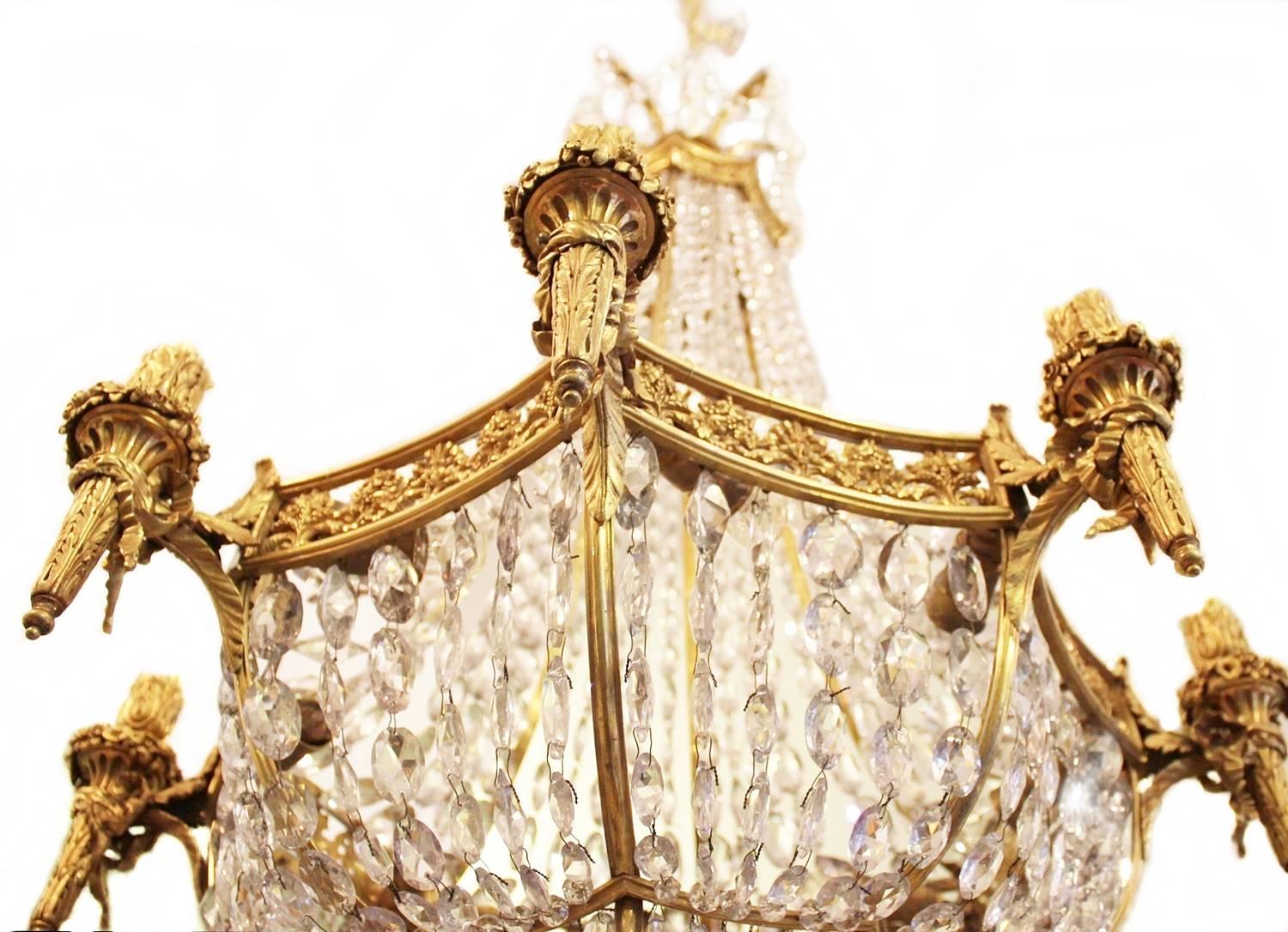This chandelier is of extremely high quality with a richly embellished and worked frame that boasts first class casting. The chandeliers candlearms is in the form of torches and are covered with a plentiful amount of Fine prisms. It is made in