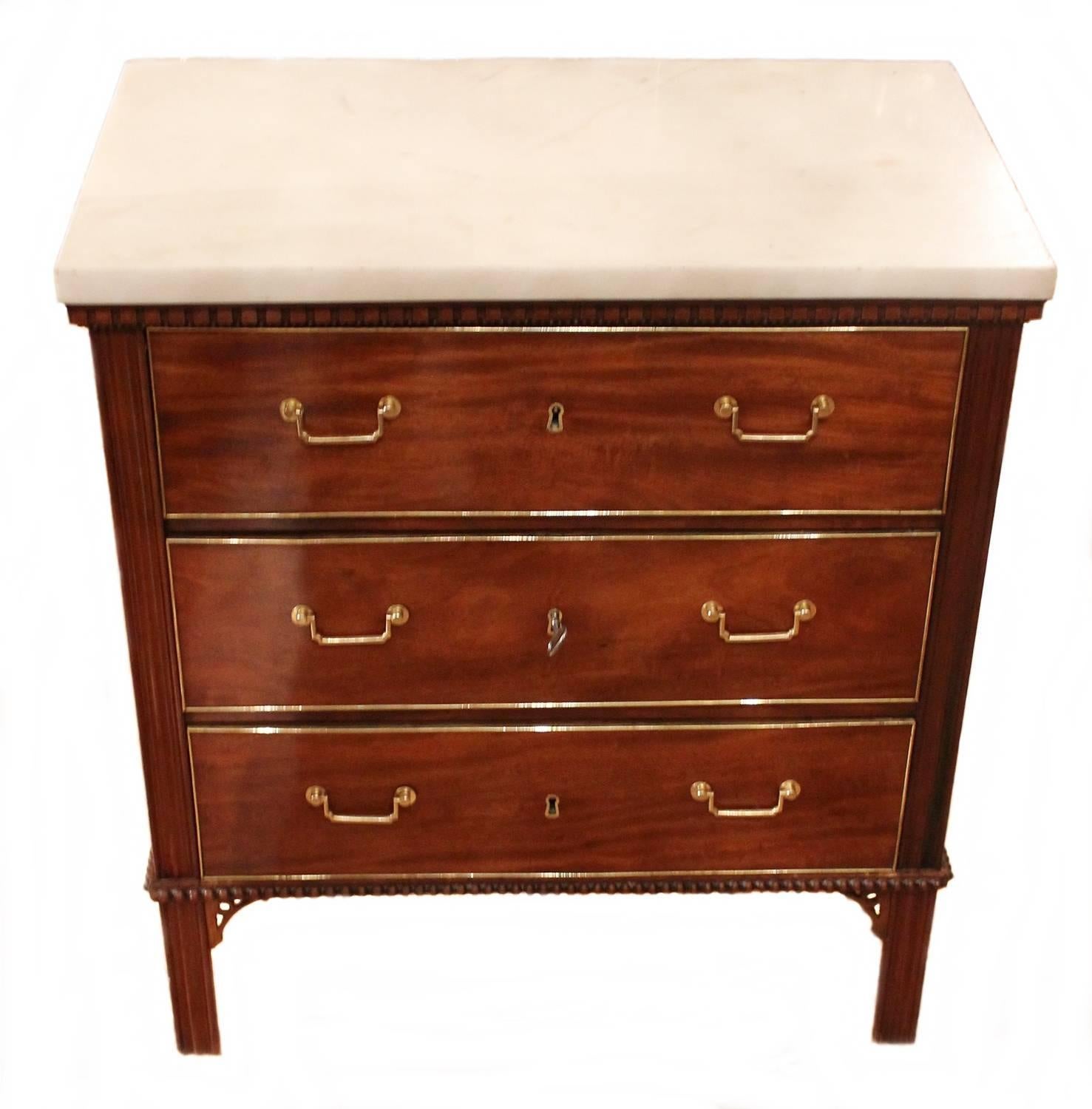 A small and classic Gustavian commode attributed to Gottlieb Iwersson (Master in Stockholm 1778-1813) circa 1795. 
Mahogany veneer, gilt brass and white marble top commode with three drawers and original locks and key. 
The definition of understated