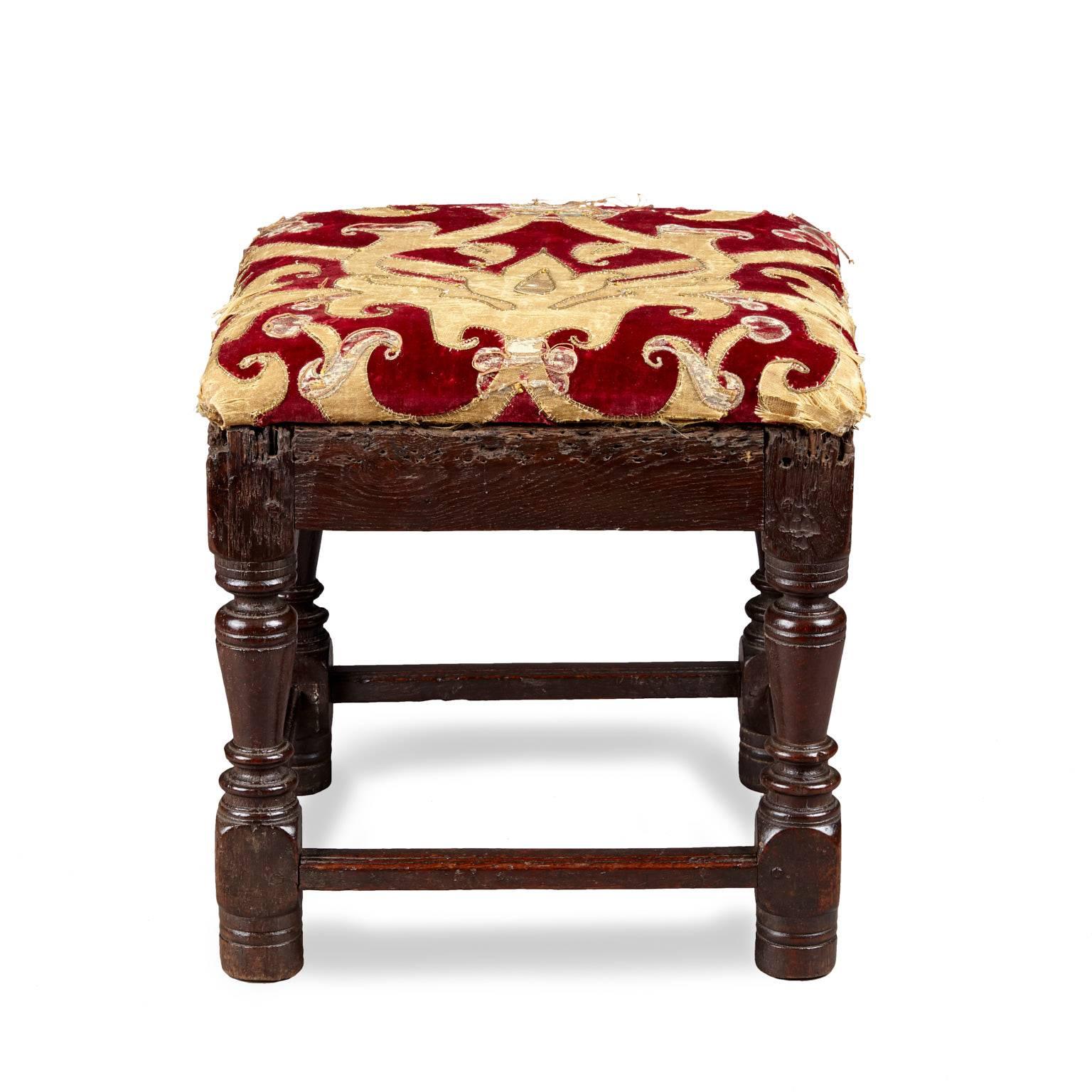 Late Elizabethan upholstered low joined stool

The square frame with inverted baluster turned legs on original high ring turned toes, joined by plain side rails with signs of previous upholstery, the lower frame with high flat moulded stretchers.
