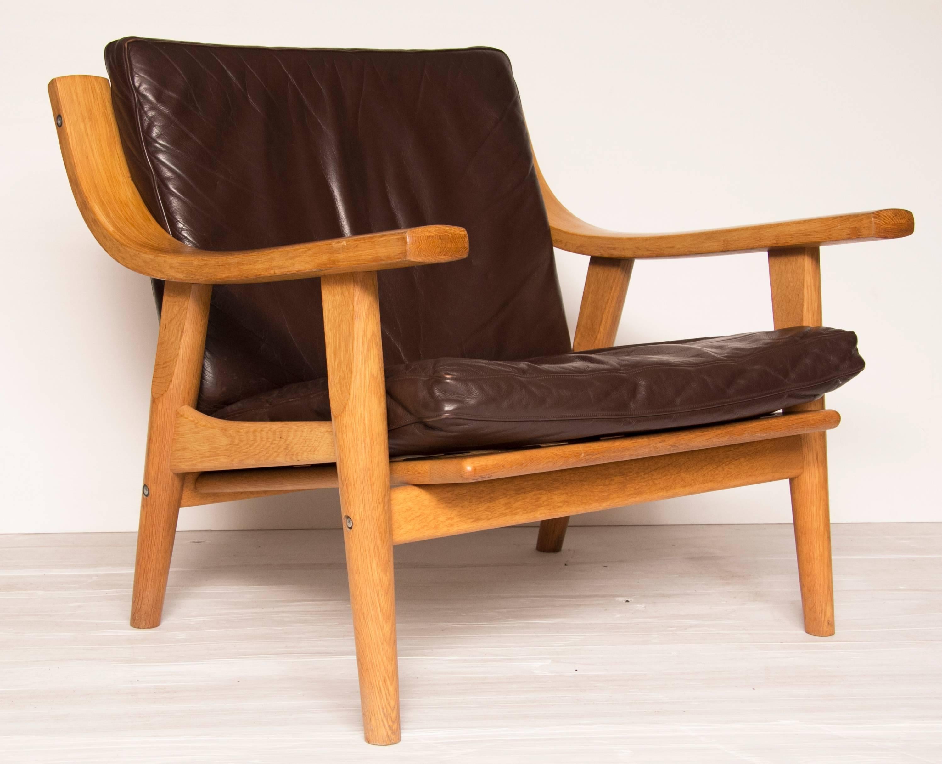 Hans Wegner GE530 oak and brown leather lounge chair. A superbly designed very comfortable chair.