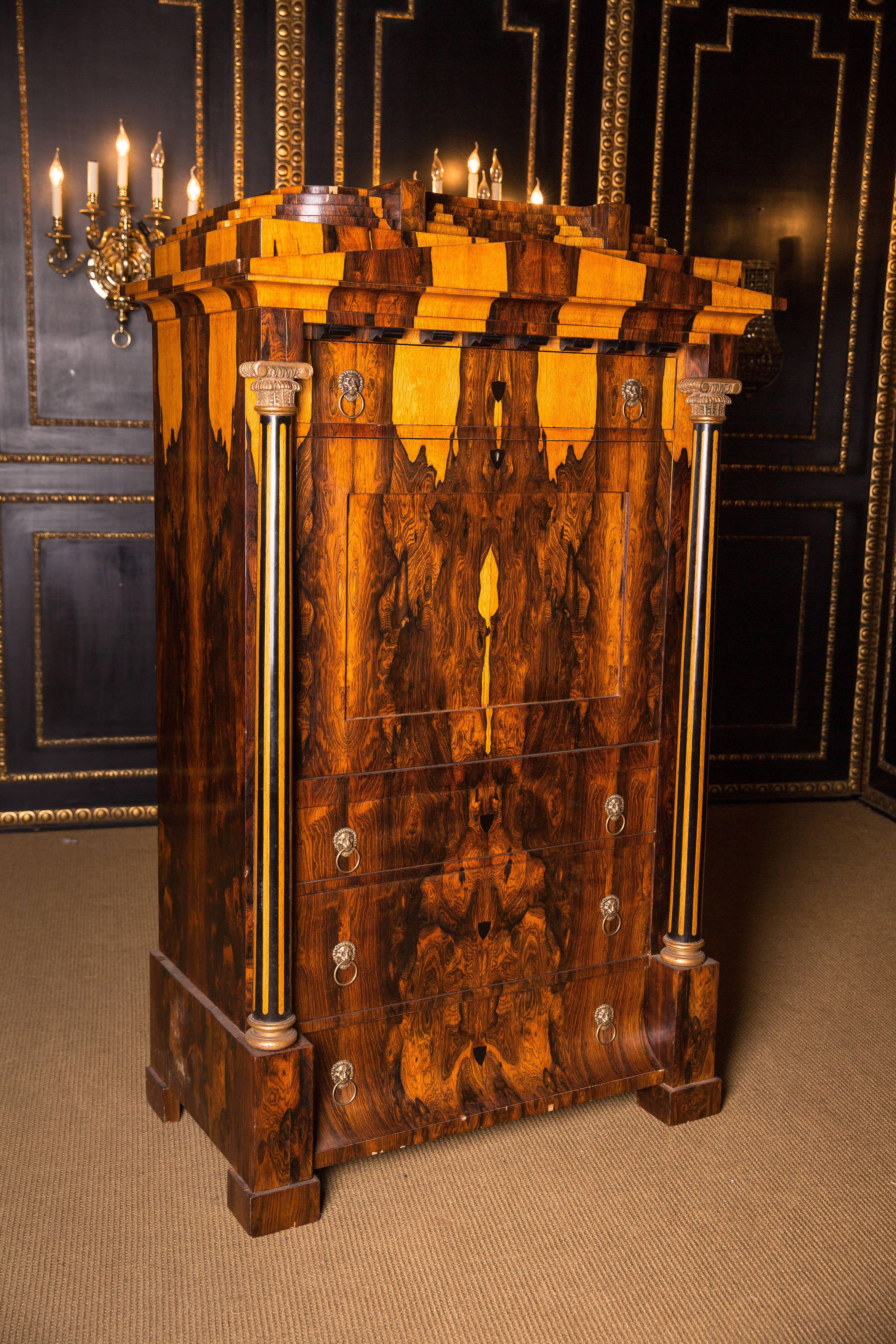 Exotic Indian Palisander on solid conifers. Architecturally arranged front. High-right body on padfoot feet. Fitted with three drawers of different sizes, the base drawer is curved. Straight writing plate, behind staggered office division. Flanked