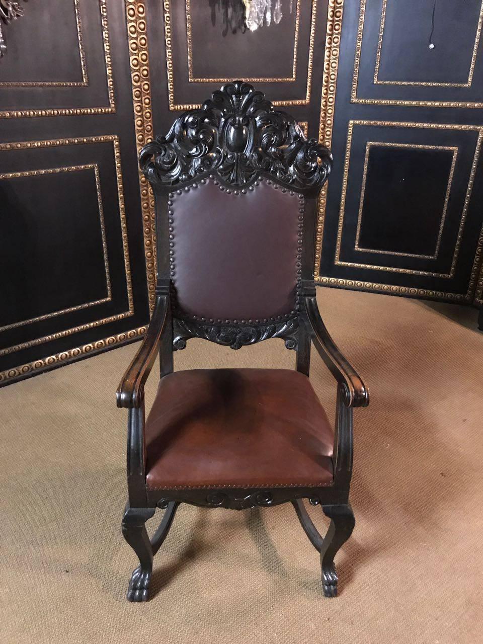 Solid oak. On four curved carved legs. Complete with rich carvings, flanked by two armrests. High backrest crowned by plastic carvings. The seat and back are leather covered in Classic design.

A good historical condition with a beautiful warm