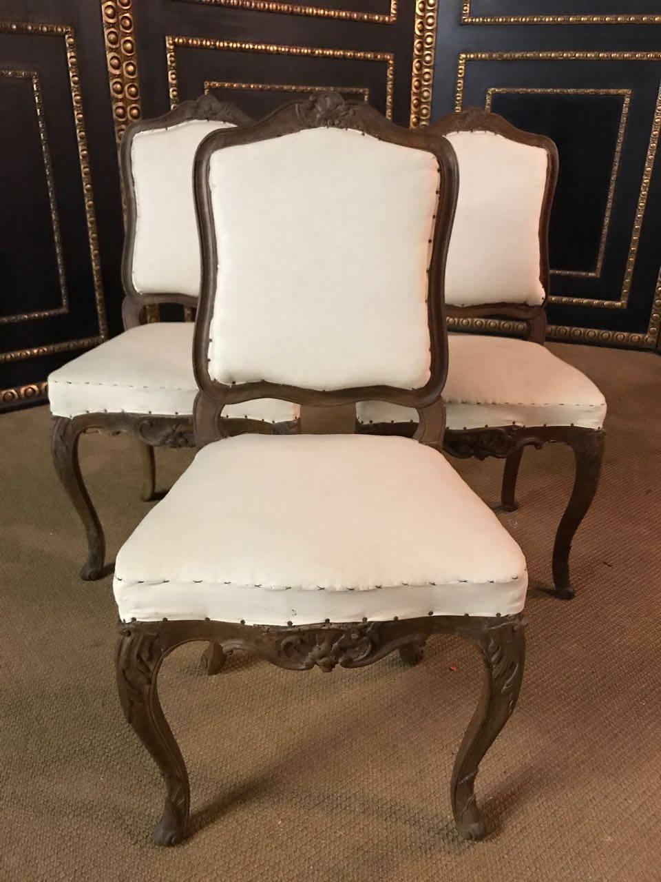 Three original museum Baroque walnut chairs, circa 1740

Solid walnut. On the curled legs, strongly cambered frame. Curved, medial-shaped backrest. Seat and backrest from the ground up newly upholstered in Classic design and with laced spring base.