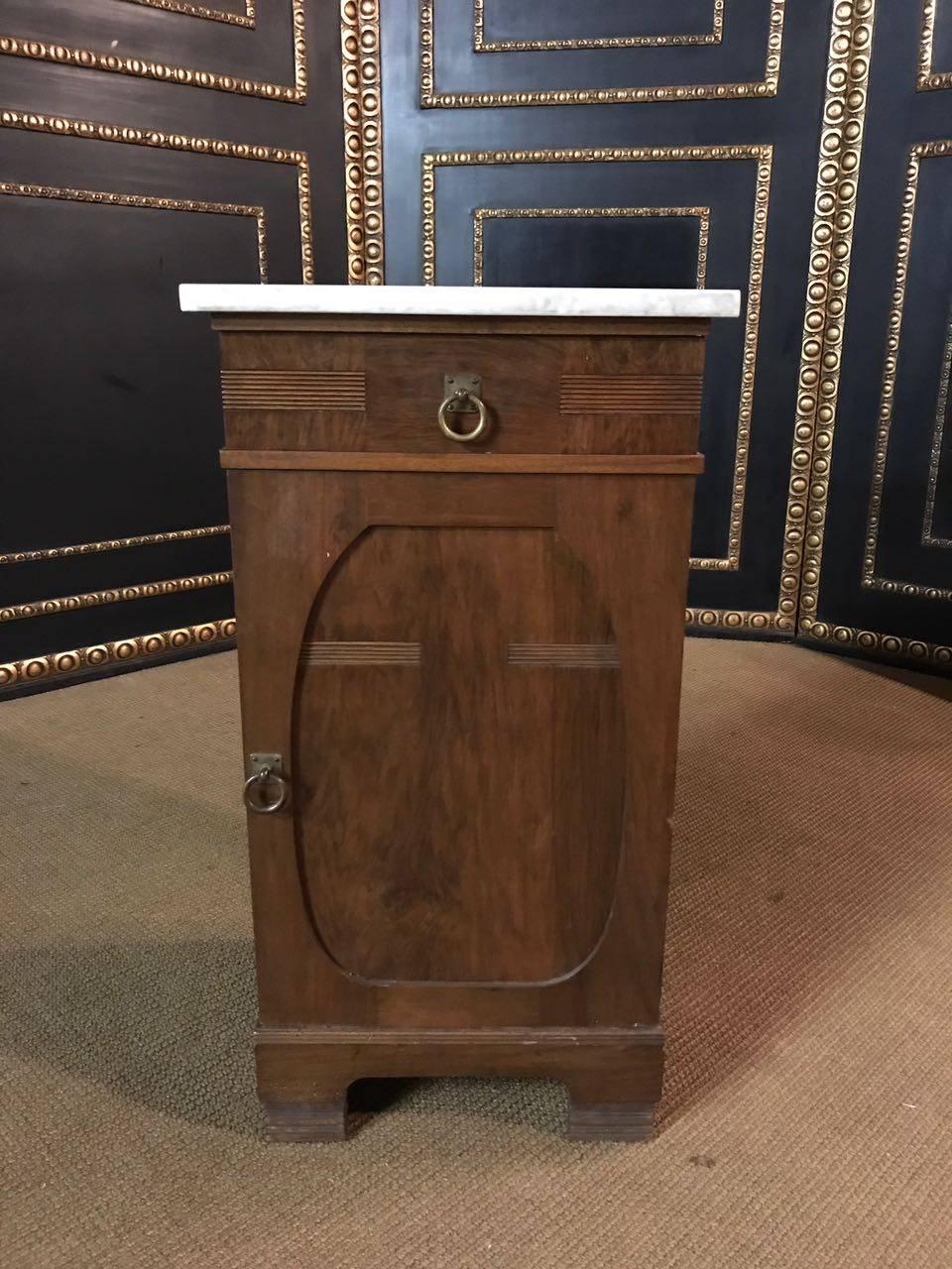 Solid wood with walnut veneer.
High-rectangular body with a drawer and a door. Marble-top.

A good historical condition with a beautiful warm patina.
 