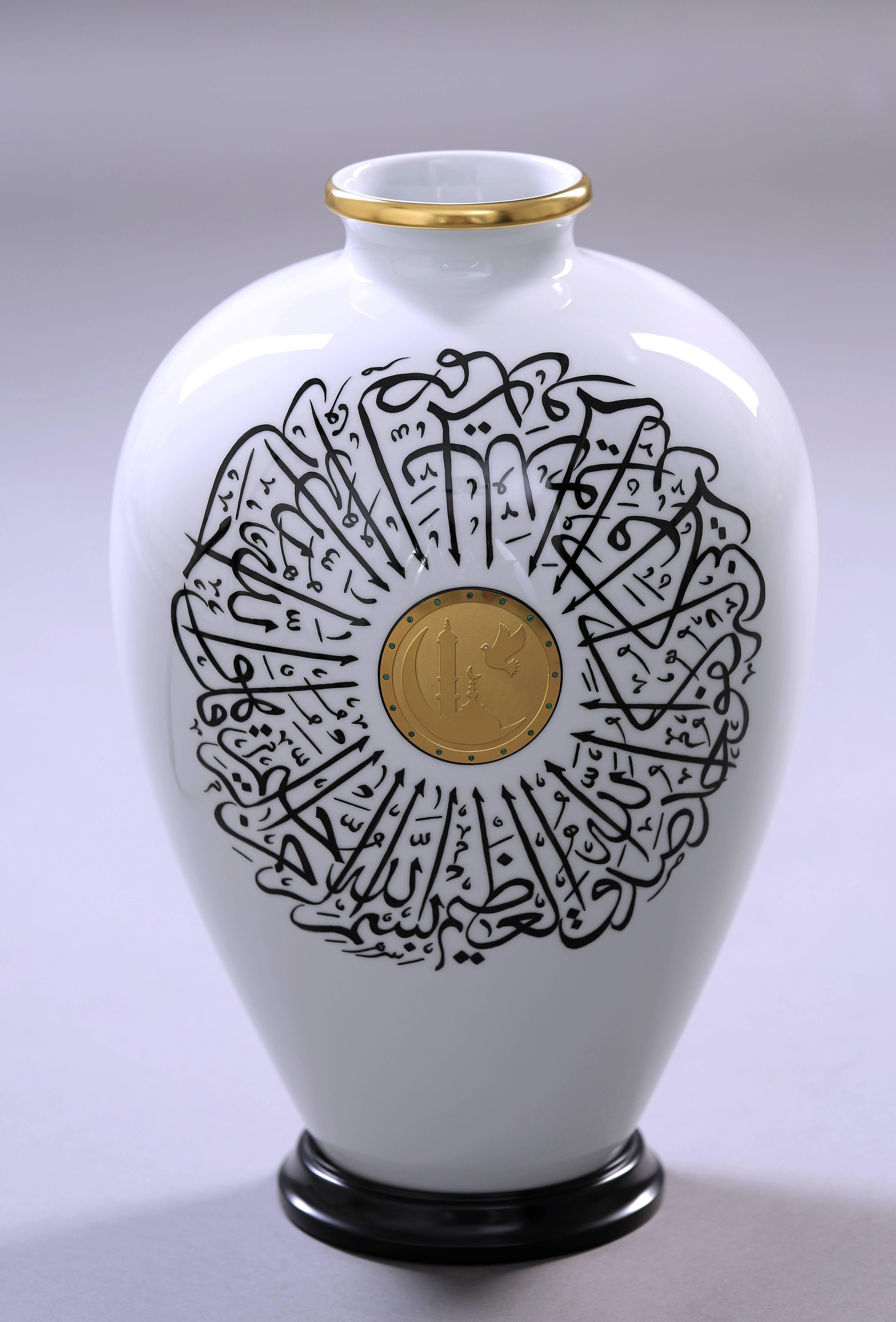 Vase. Porcelain of the highest quality. Hand engraving of the Holy Quran Surat al-Ichlas. Five layers of 24-carat gold plating. Incrustation with sixteen emeralds and a brilliant. Wooden stand. Measure: Height 44 cm. Unique item.

We are glad to