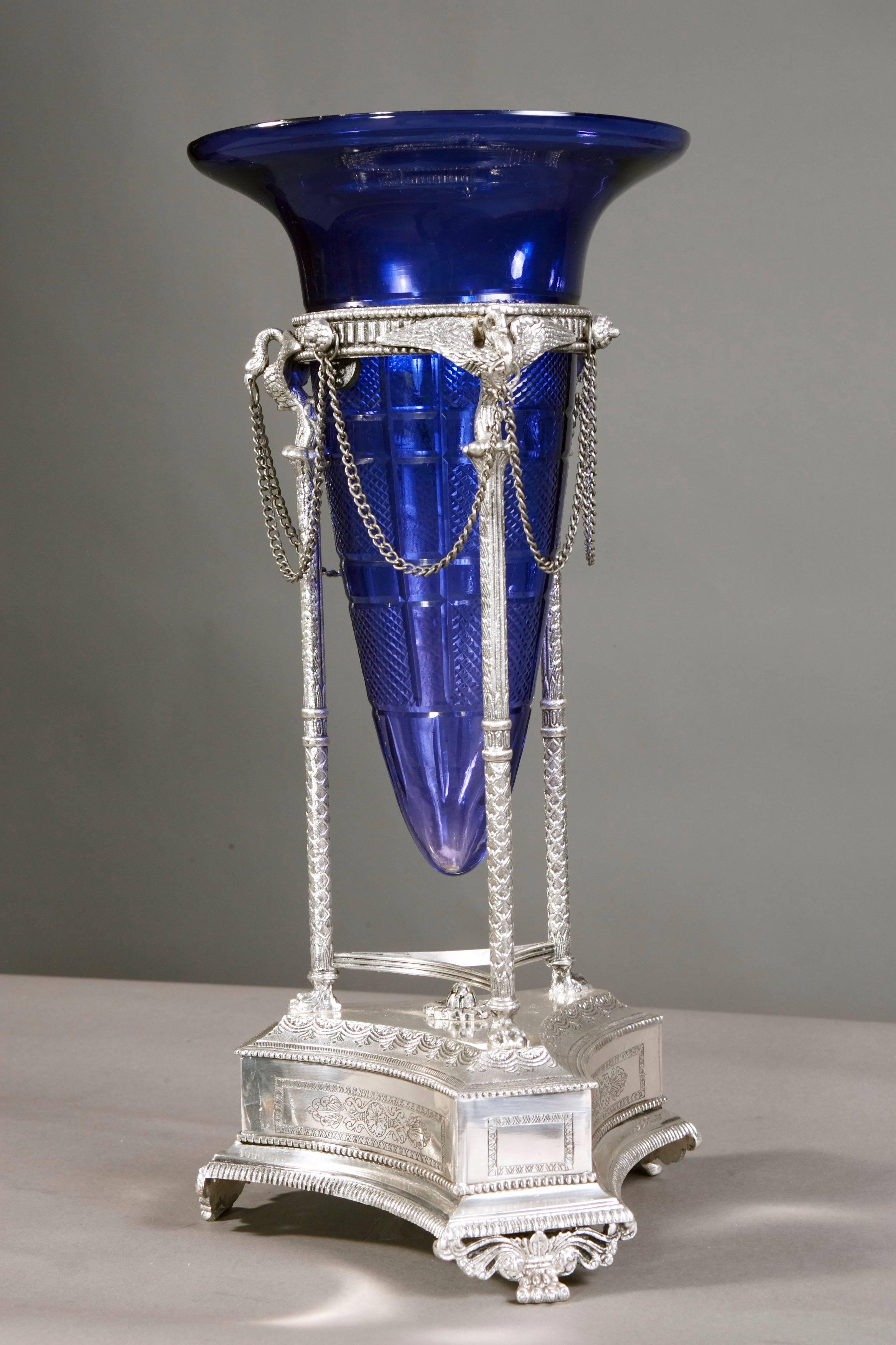 On three-legged, curved plinth on three flared feet with leaf-neck. Three column shafts with fully sculptural, finely chiselled swans. Funnel-shaped insert made of sapphire-blue glass with rich cut decoration. Everything from solid and antique