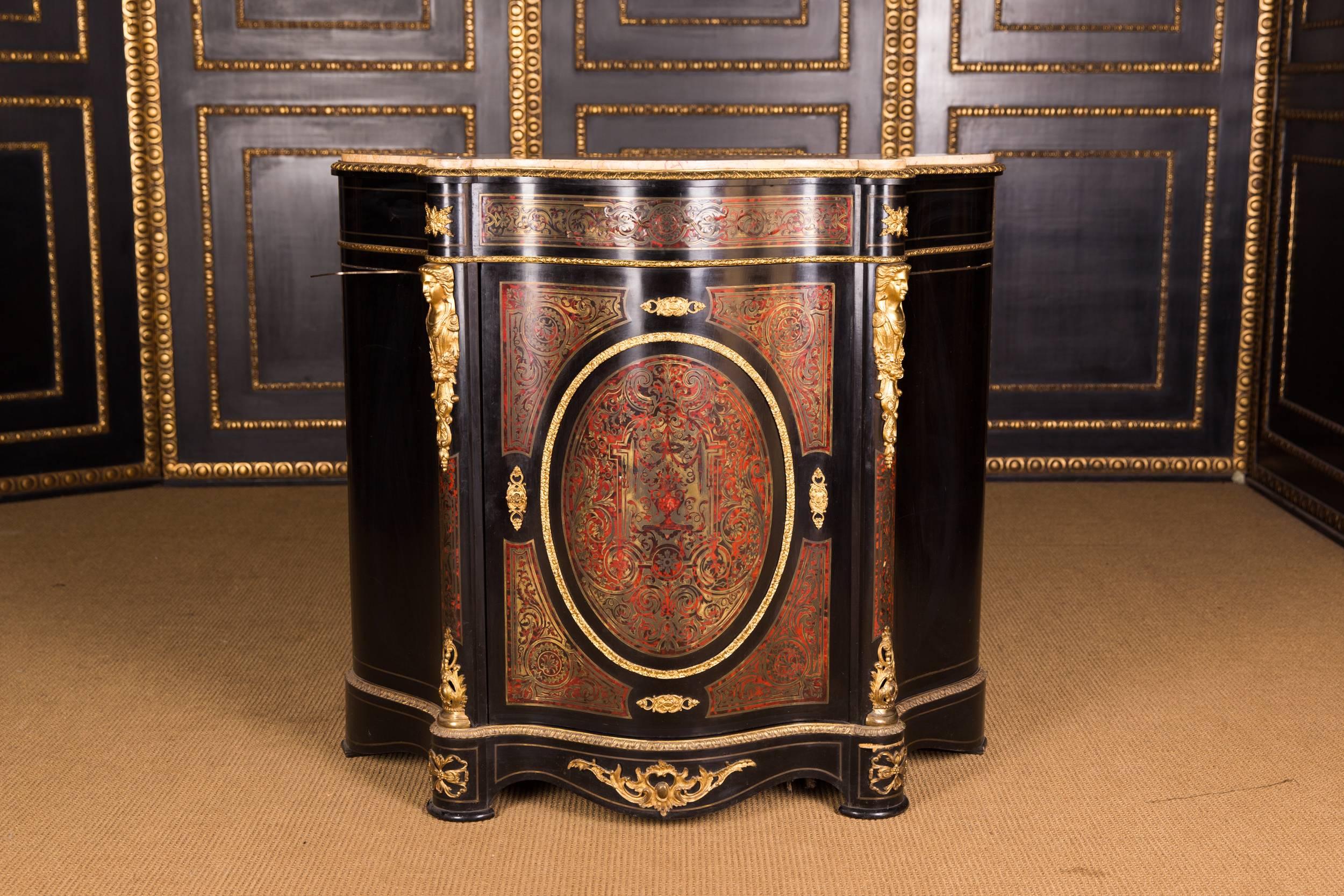 Corpus ebonized on softwood. High-rectangular body with brass and tortoiseshell insert. In the articulated front is a wide curved door with tortoiseshell, flanked by bronze appliques. Slightly protruding profiled frame with marble. The fittings are