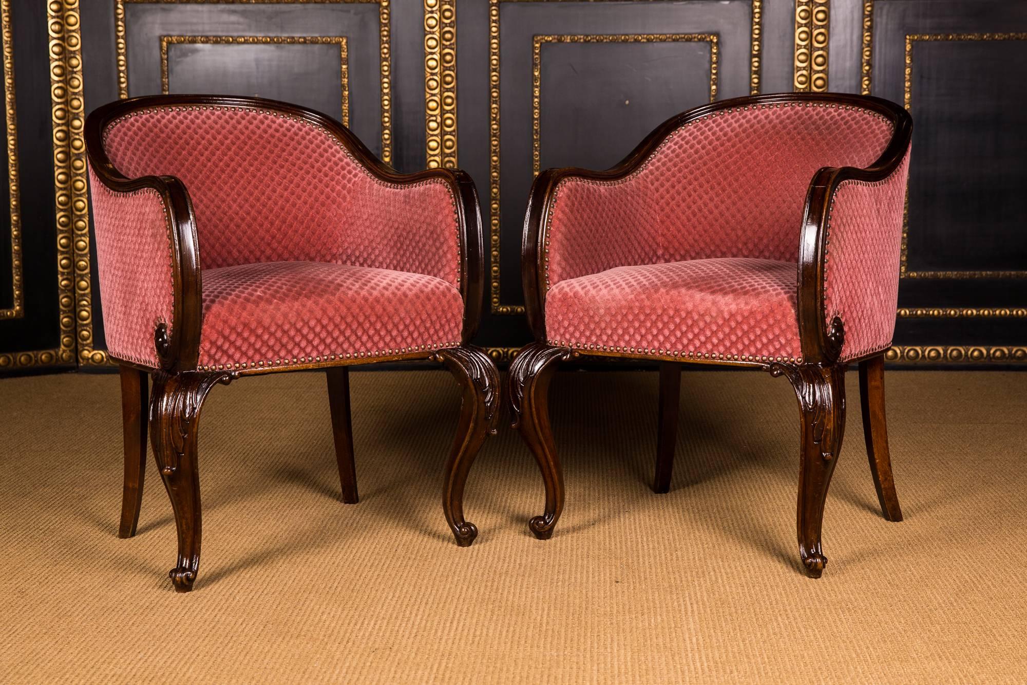 Solid mahogany wood. On curved and partially carved legs. Slightly cambered frame. Bilateral armrests bent. The hind legs are slightly outward. Curved backrest. The seat and backrest are covered with velvet.

Excellent warm patina aged over decades.