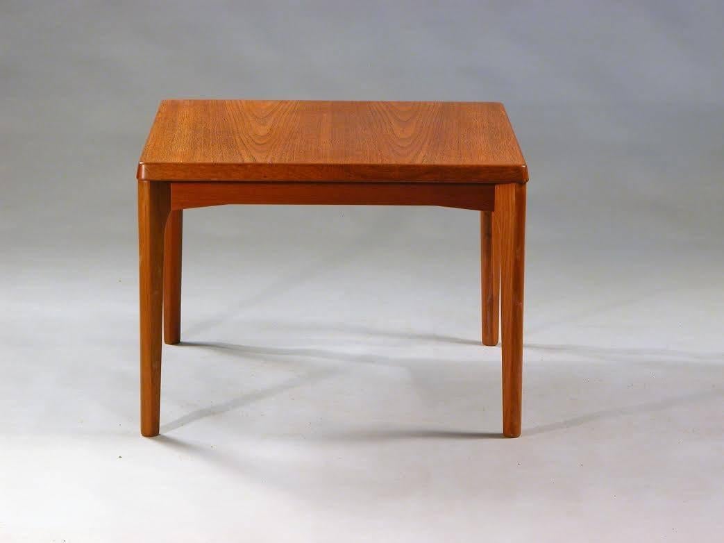 Side table in teak designed by Henning Kjærnulf for Vejle Møbelfabrik in the 1960s.

The square seized side table has elegant curves and rounded edges that makes it look much smaller than it actually is. 
 
If you are interested in this item feel