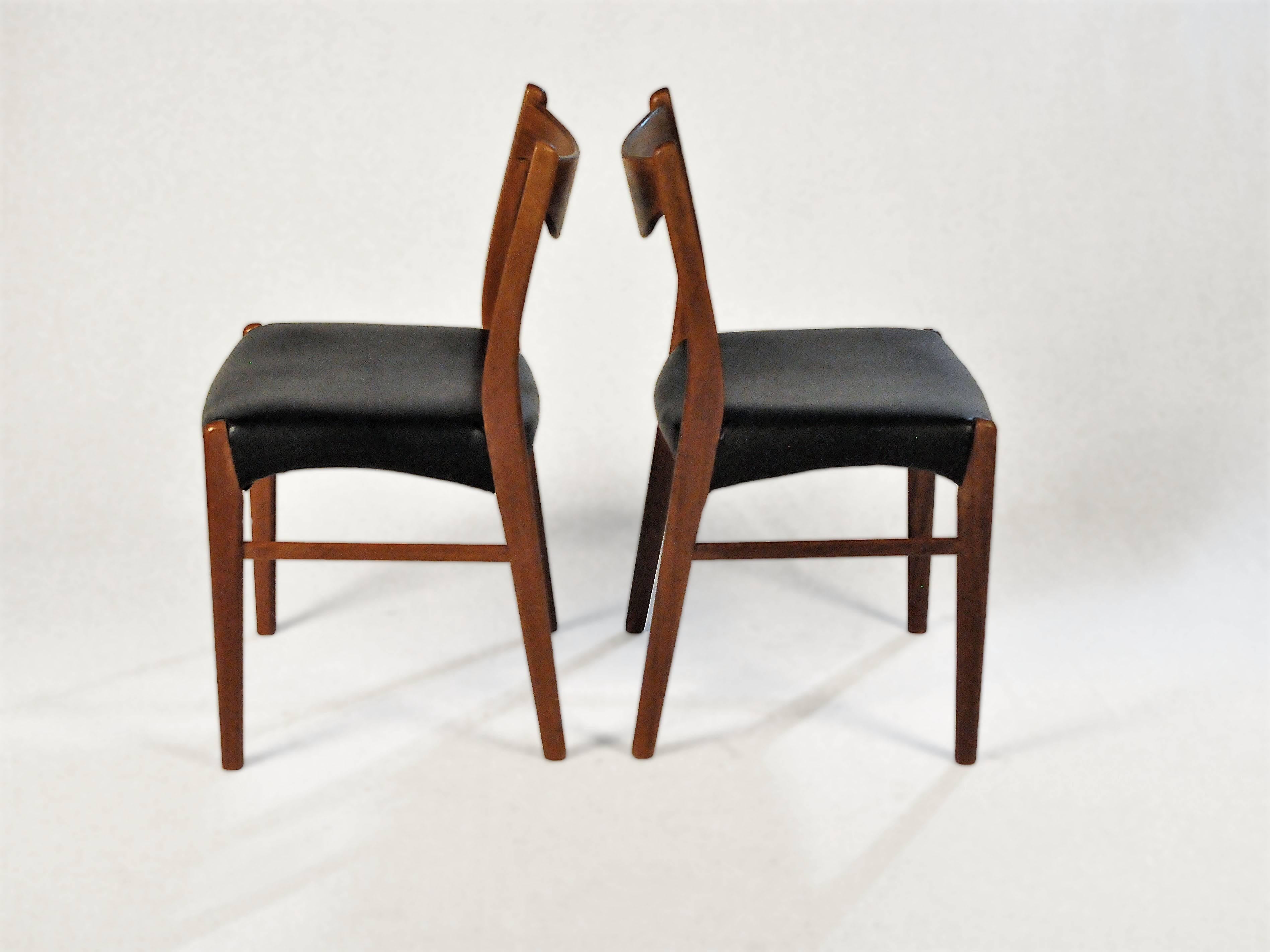 Two dining chairs in teak and leatherette designed by Ejnar Larsen and Axel Bender Madsen and produced by Glyngøre Stolefabrik in the 1960s

The dining chairs are in good condition and have a very streamlined modern flare to them with backrests