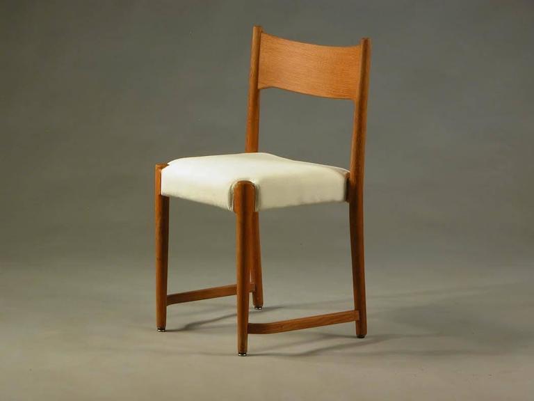 This reupholstered oak dining chair is was one of Hans J. Wegners earliest designs. The model was first produced by Plan Møbler in 1940/1941 for the new iconic city hall in Aarhus that was finished in 1941 with Arne Jacobsen as architect and a young