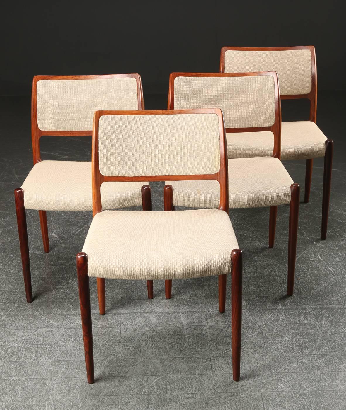This set of four model 80 dining chairs in rosewood and beige fabric with Niels Otto Møllers characteristic organic shapes and the high standard of craftmanship from J.L. Møller are in a very good condition with minor wear consistent with age and
