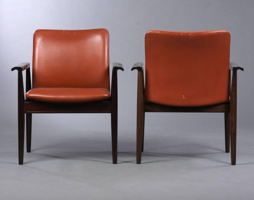 Finn Juhl designed the model 209 chairs in 1961. The chair is part of a series of furniture named the Diplomat series with chairs, desks, tables, cabinets and other furniture.

The chairs features mahogany frames and brown leather upholstery and