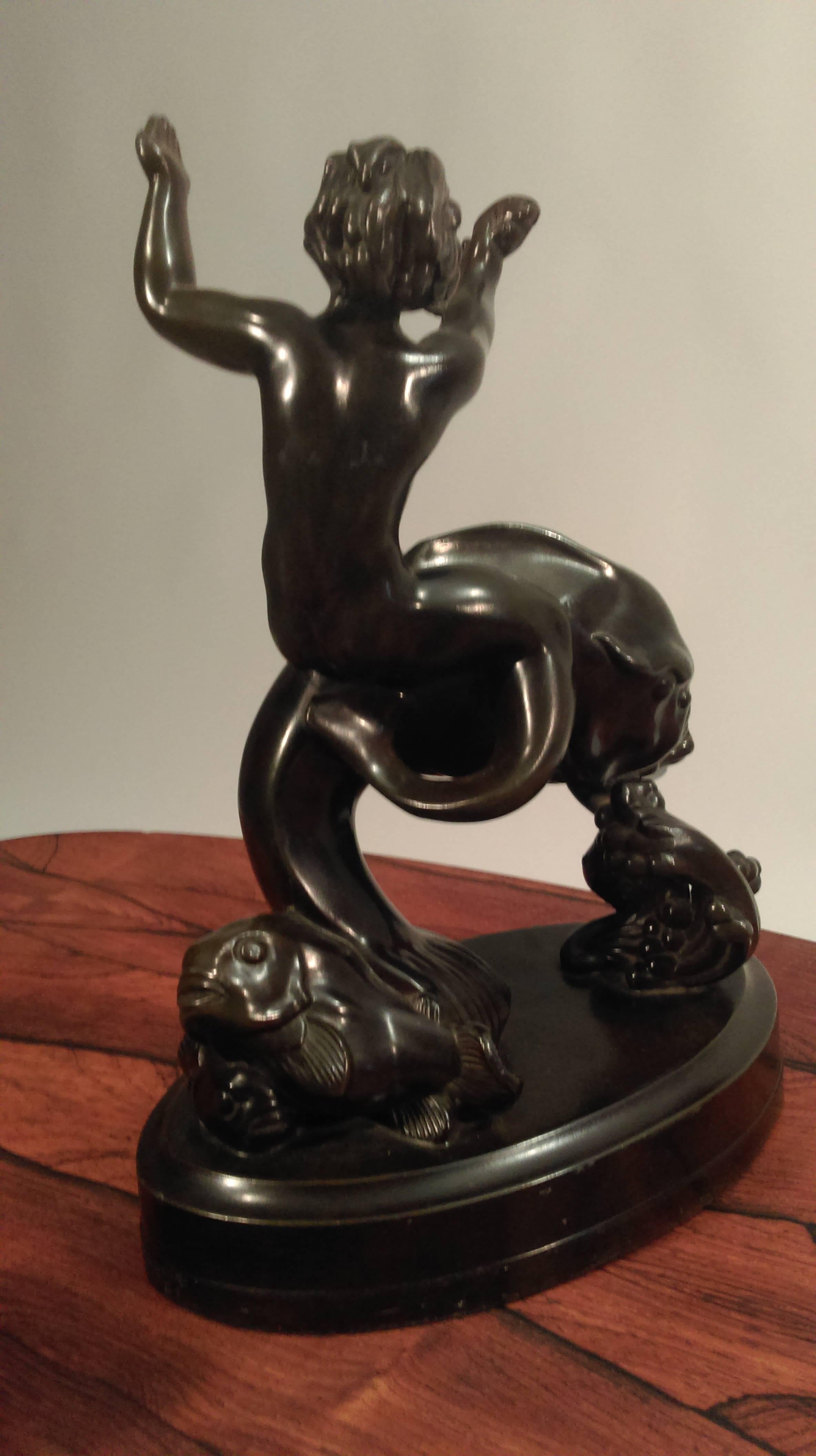 Just Andersen 1884 - 1943 - sculpture of a merman and fish with lots of details that catch the eye.

The sculpture is one of Just Andersens most advanced sculptures and in very good condition. The sculpture is made of black disco metal - an alloy of