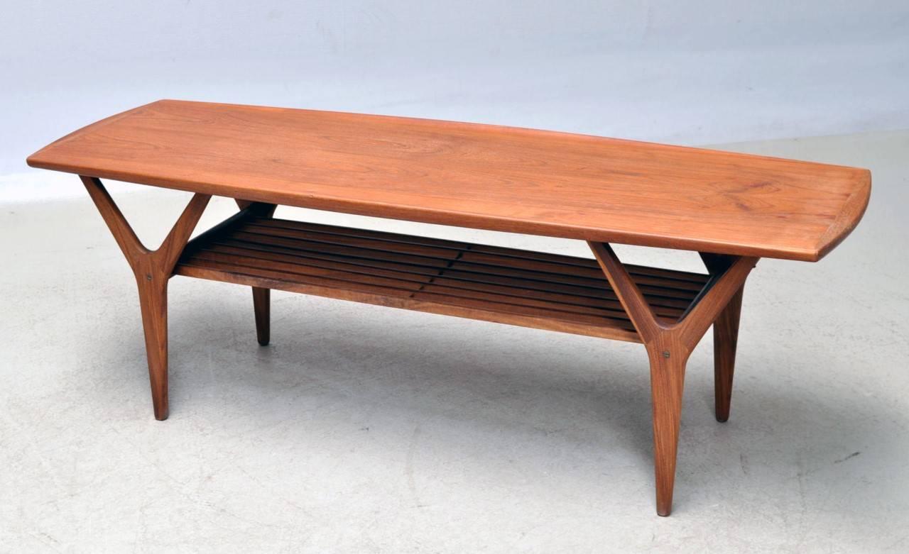 Elegant refinished coffee table / side table / sofa table in teak with shelf made of solid teak bars designed by Henning Kjaernulf in the 1960s.