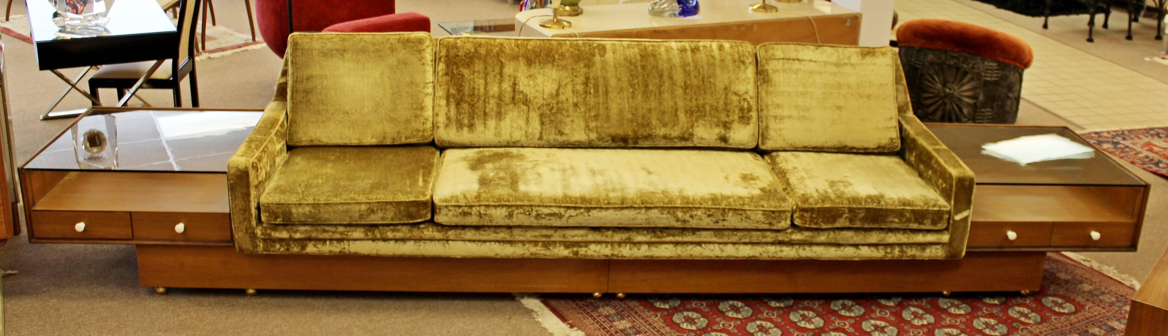 For your consideration is a rare and unique sofa on a walnut plinth base, with two attached side tables with glass tops, attributed to Adrian Pearsall. The whole piece is on brass caster wheels for easy mobility. Chartreuse crushed velvet
