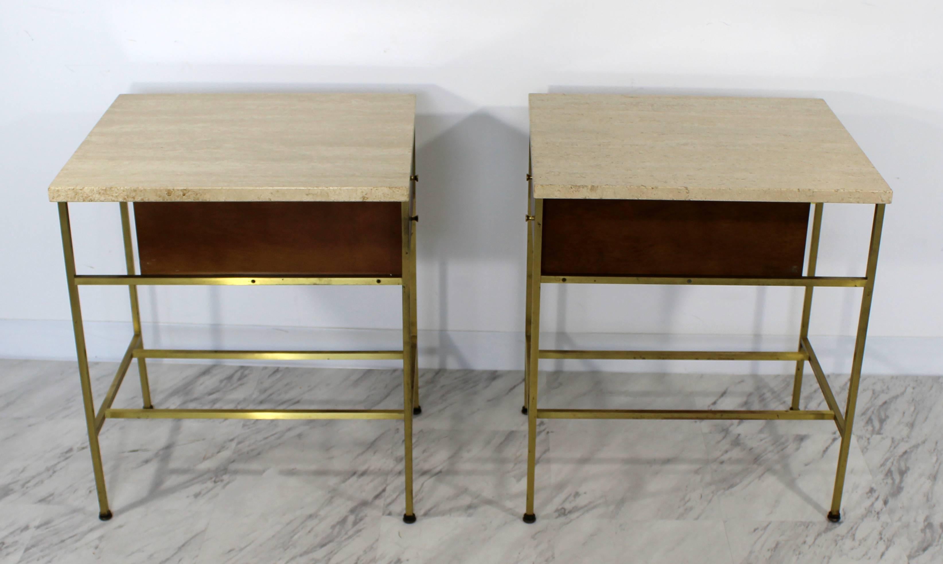 For your consideration is a standout pair of nightstands or side tables, with travertine tops, brass bases and two drawers each, designed by Paul McCobb for Calvin's Irwin collection. In very good condition. The dimensions are 20