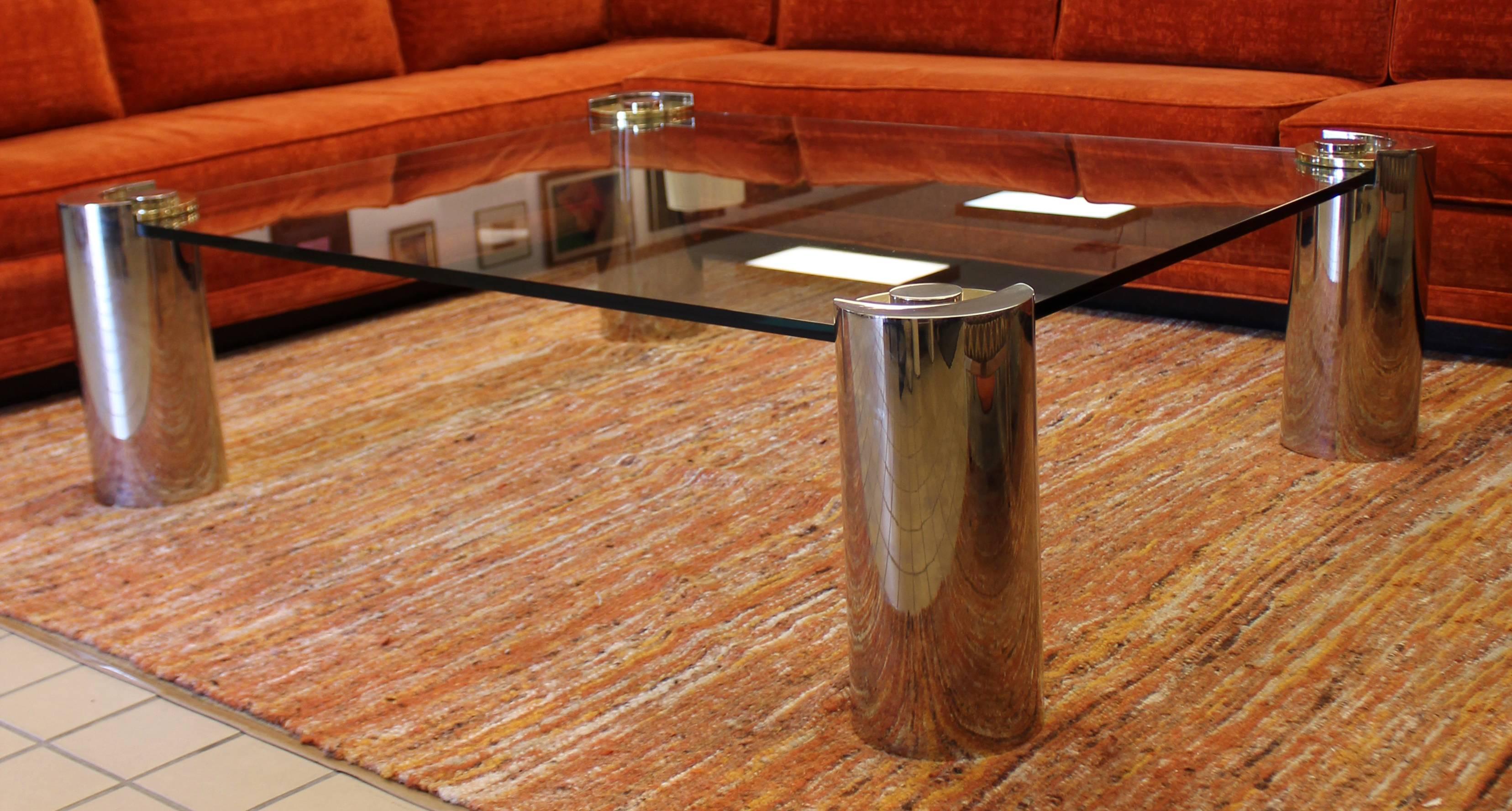 For your consideration is an incredible coffee table, with a glass top inset into four brass and chrome, cylindrical legs, designed and signed by Karl Springer, circa the 1970s. In excellent condition. The dimensions are 52
