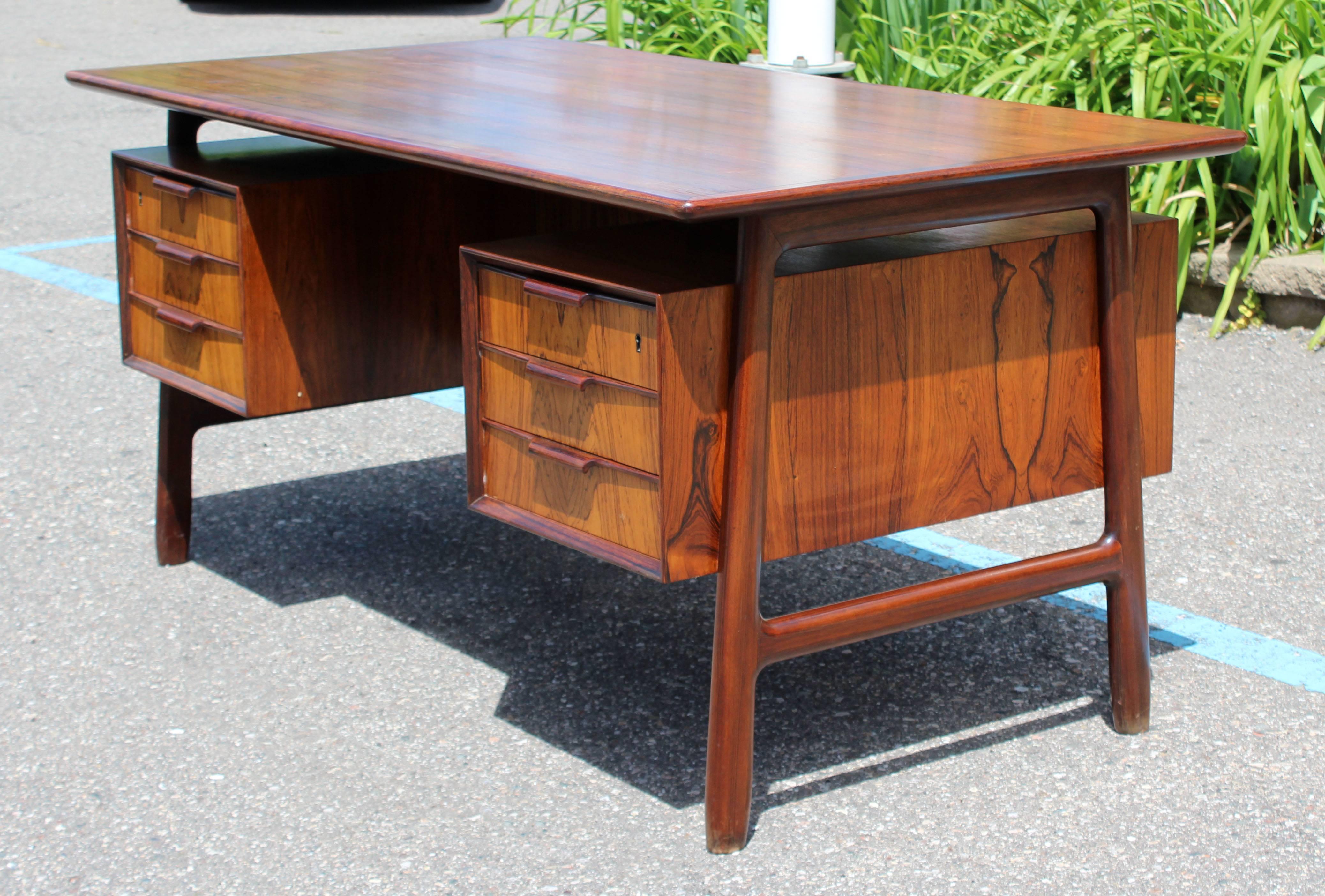 For your consideration is a fabulous, six-drawer, floating top rosewood desk from Denmark, by Gunni Omann in the 1960s. In excellent condition. The dimensions are 55