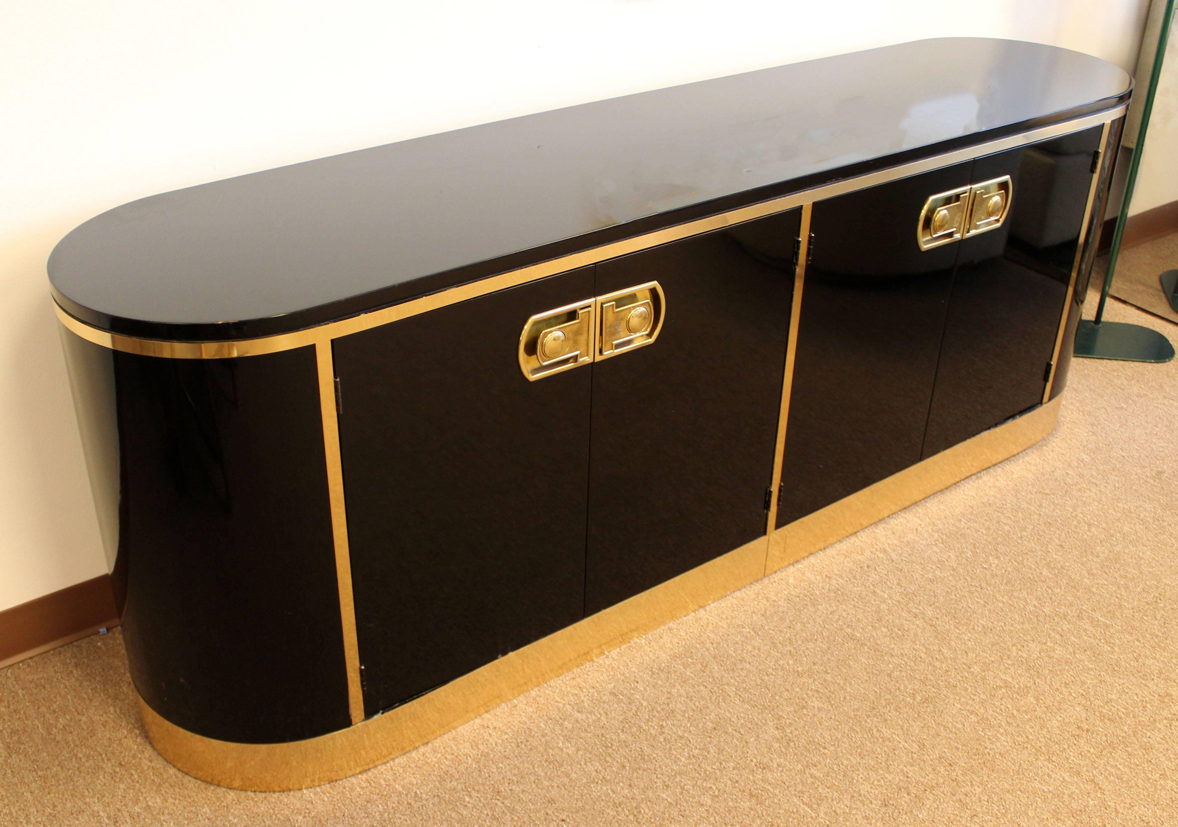 For your consideration is a magnificent, black lacquer credenza, with brass pulls and trims, from Mastercraft, circa the 1970s. In excellent condition. The dimensions are 80