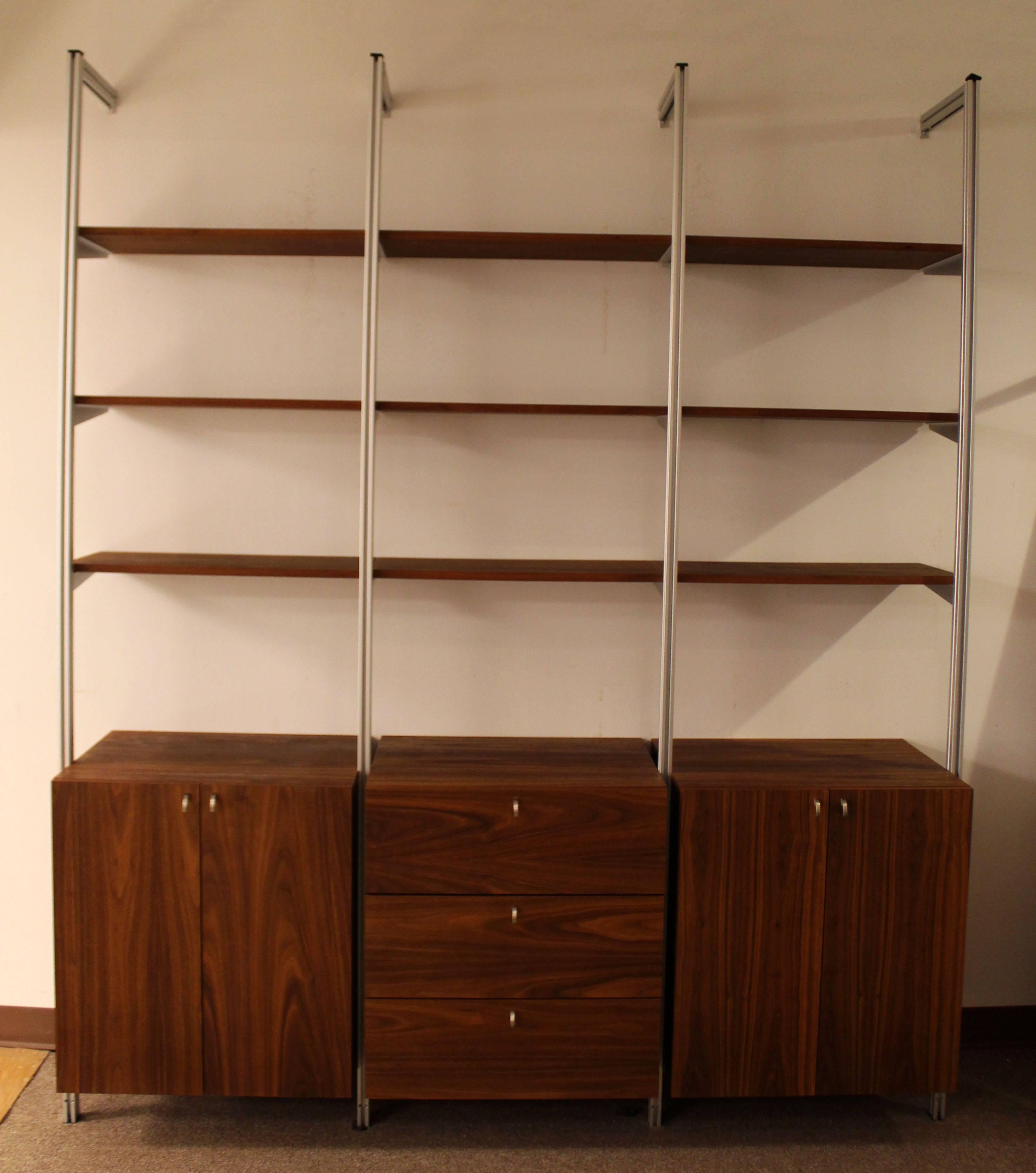 For your consideration is a fantastic, compact shelving system, with nine shelves, three drawers and two cabinets, attributed to George Nelson CSS system. In excellent condition. The dimensions are 76