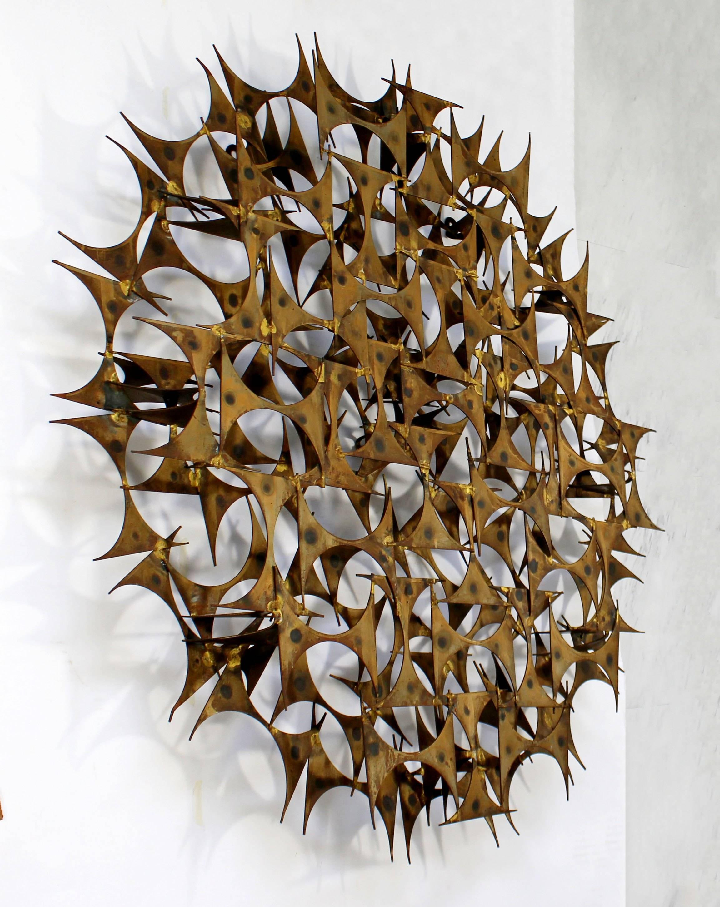 For your consideration is a brilliant, Brutalist wall sculpture, reminiscent of a shining sun, by Marc Weinstein Creates, circa 1970s. In excellent condition. The dimensions are 34