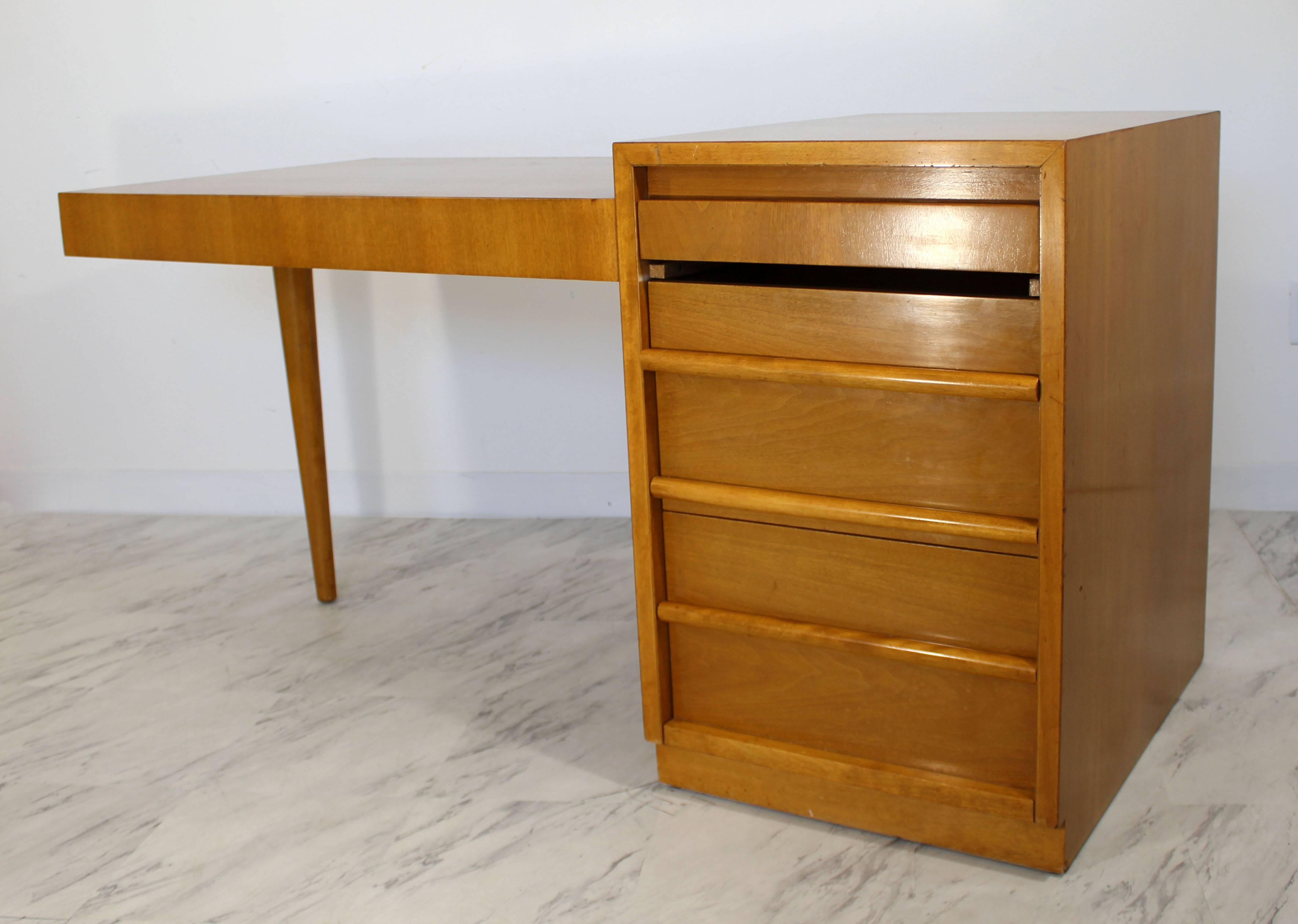 For your consideration is a rare sturdy and stunning, Cantilever walnut desk, with four, utilitarian compartment drawers. This unique legged desk was designed by T.H. Robsjohn-Gibbings for Widdicomb in the 1950s. The dimensions are 60" (5') W x