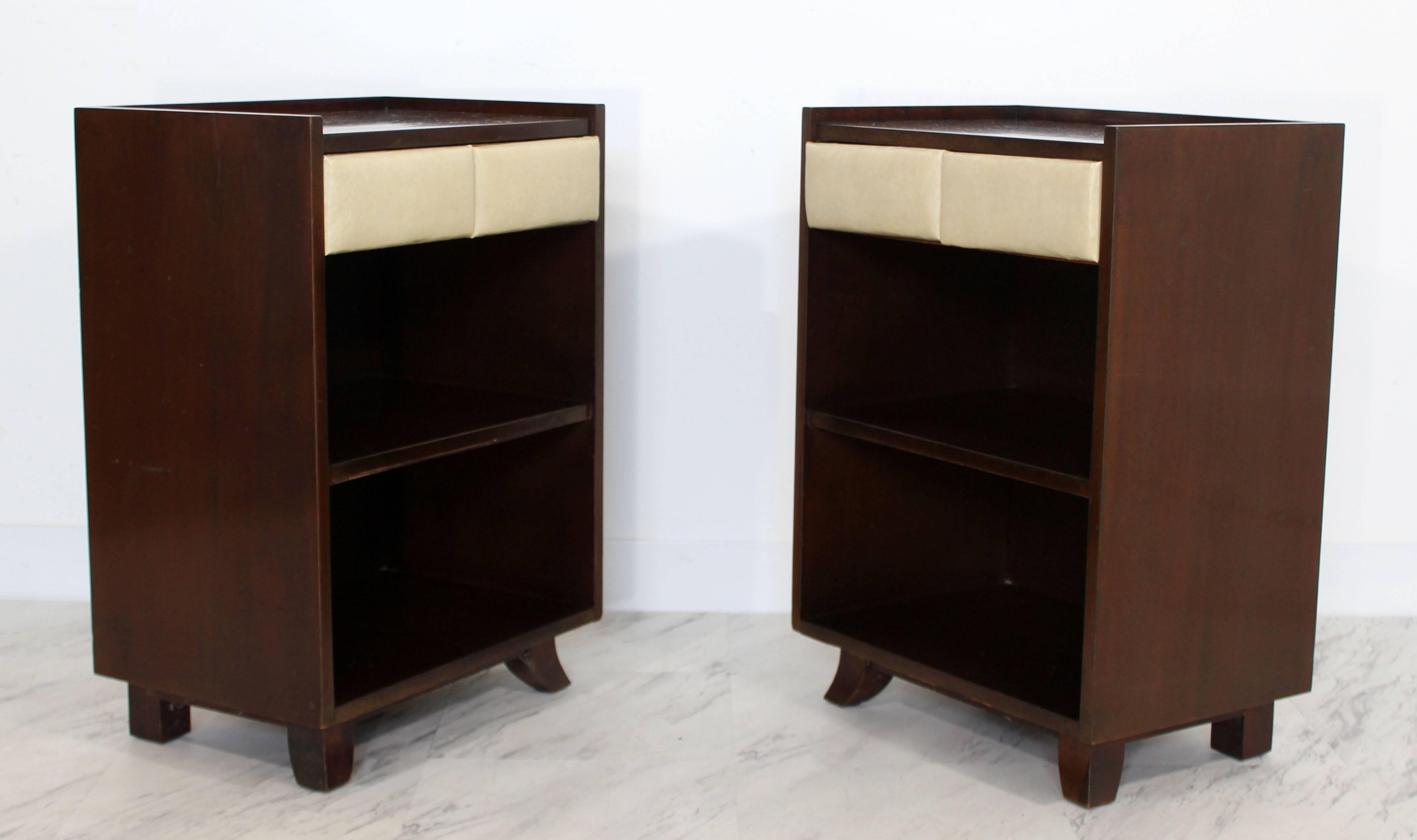 For your consideration is a wonderful pair of mahogany nightstands, with padded cream drawers, by Gilbert Rohde, circa the 1930s. In excellent condition. The dimensions are 18