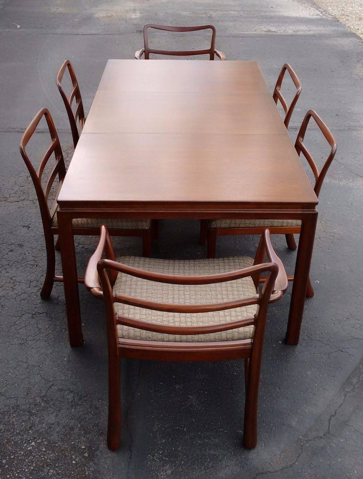 For your consideration is a brown mahogany dining table by Dunbar with six chairs, four side chairs and two with arms, and one leaf. In excellent condition. Professionally restored and refinished. The dimensions of the chairs with arms are 33