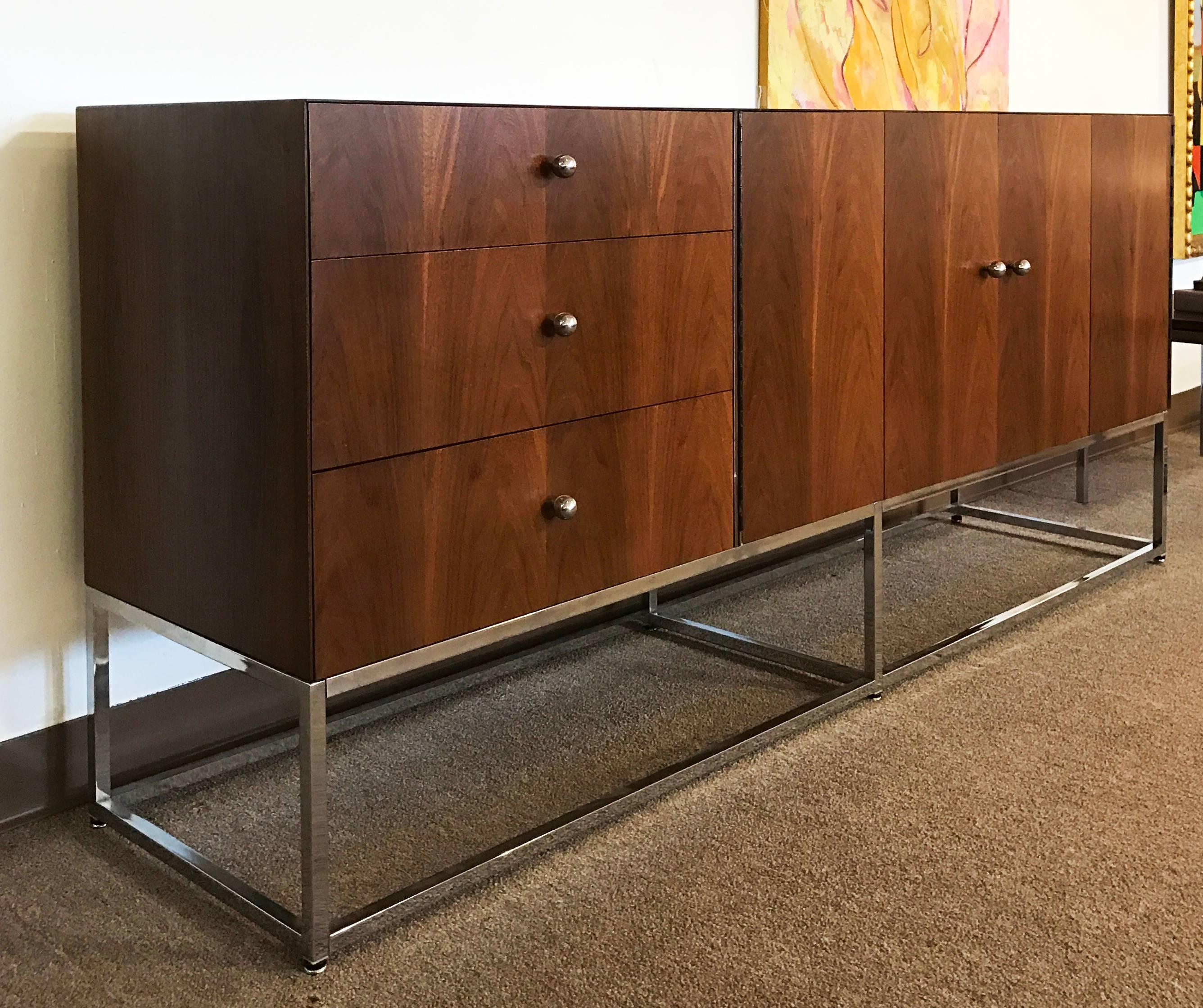 For your consideration is an absolutely gorgeous walnut wood credenza, with three drawers and two hinged doors, on a floating chrome base by Milo Baughman for Rougier. In excellent condition. The dimensions are 76