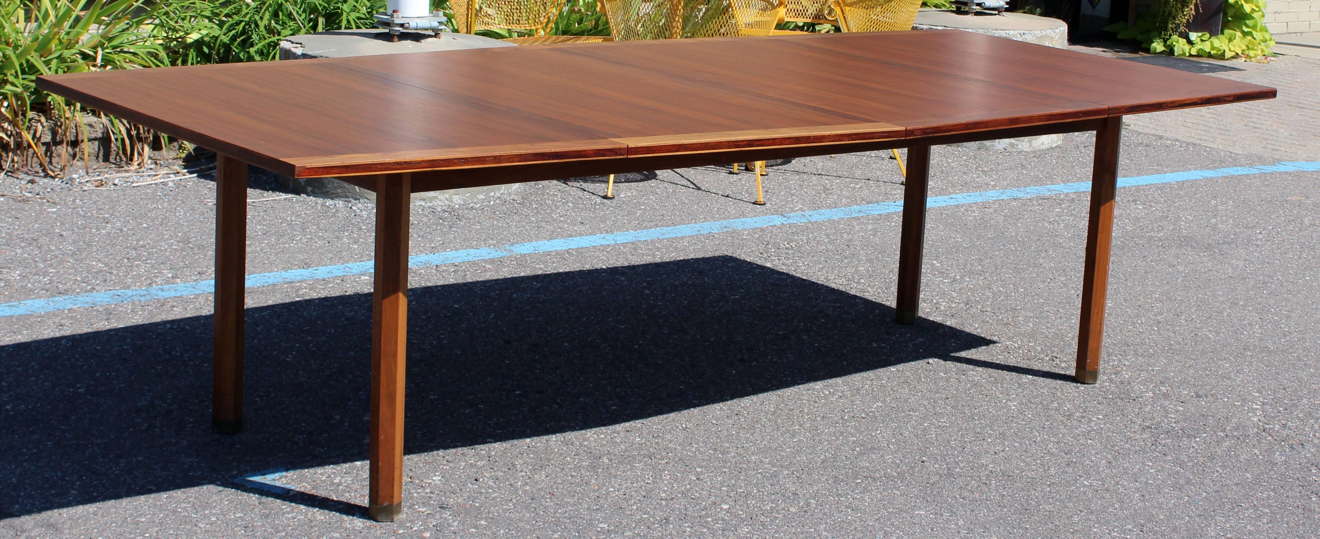 For your consideration is a uniquely fabulous and rare dining or conference table, by Dunbar, with two leaves, circa 1960s. Beautiful brass feet caps. Top just came back from being professionally refinished. In excellent condition. The dimensions