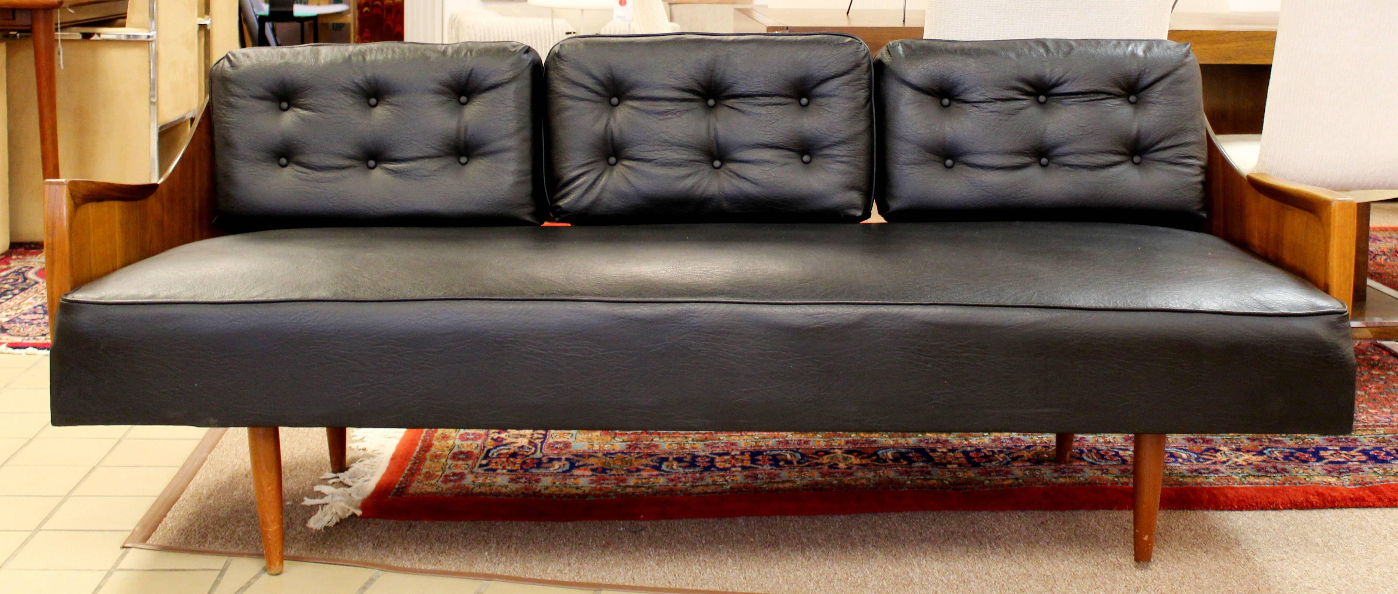 For your consideration is a fabulous, black vinyl and walnut, curved back sofa, made in Denmark circa the 1960s. In excellent condition. The dimensions are 74