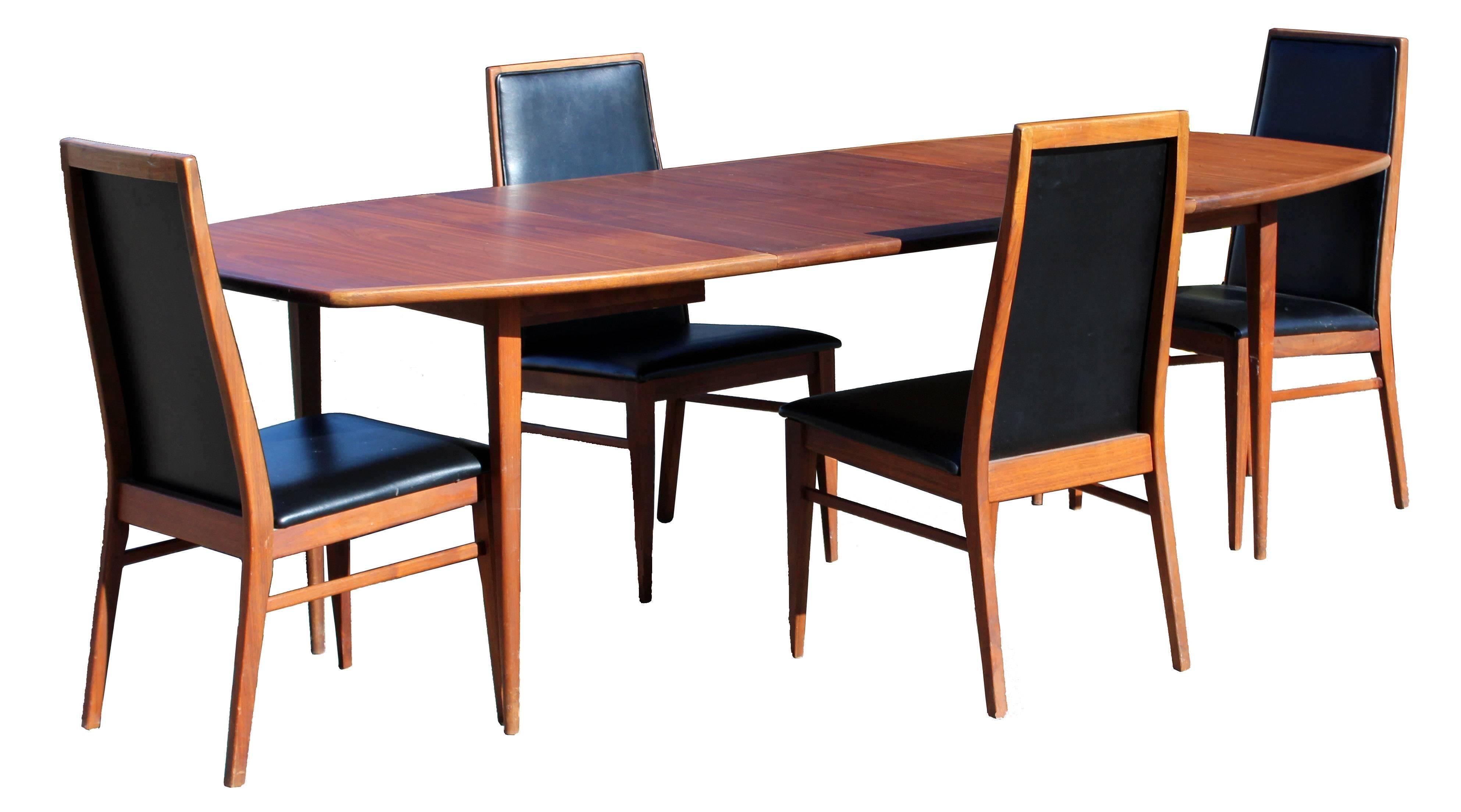 For your consideration is a fabulous dining set, made of walnut, including a dining table, with two leaves, four side dining chairs and a matching credenza, by Dillingham Furniture, circa 1970s. In excellent condition. The dimensions of the table
