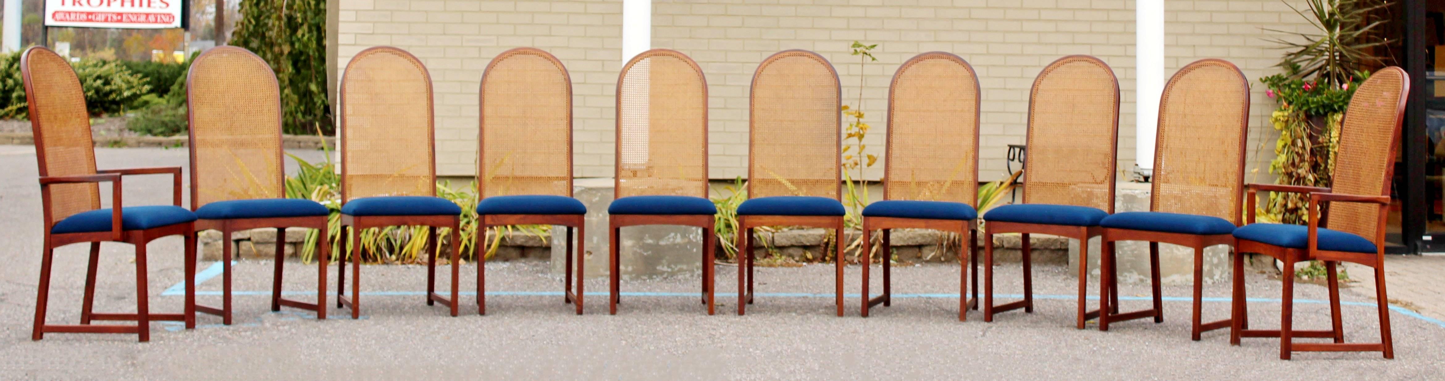 For your consideration is a breathtaking set of ten dining chairs, eight-side and two-arm, by Milo Baughman for Directional, circa 1960s. The cathedral style bases are made of solid walnut and cane, and have blue, fabric seats. In excellent