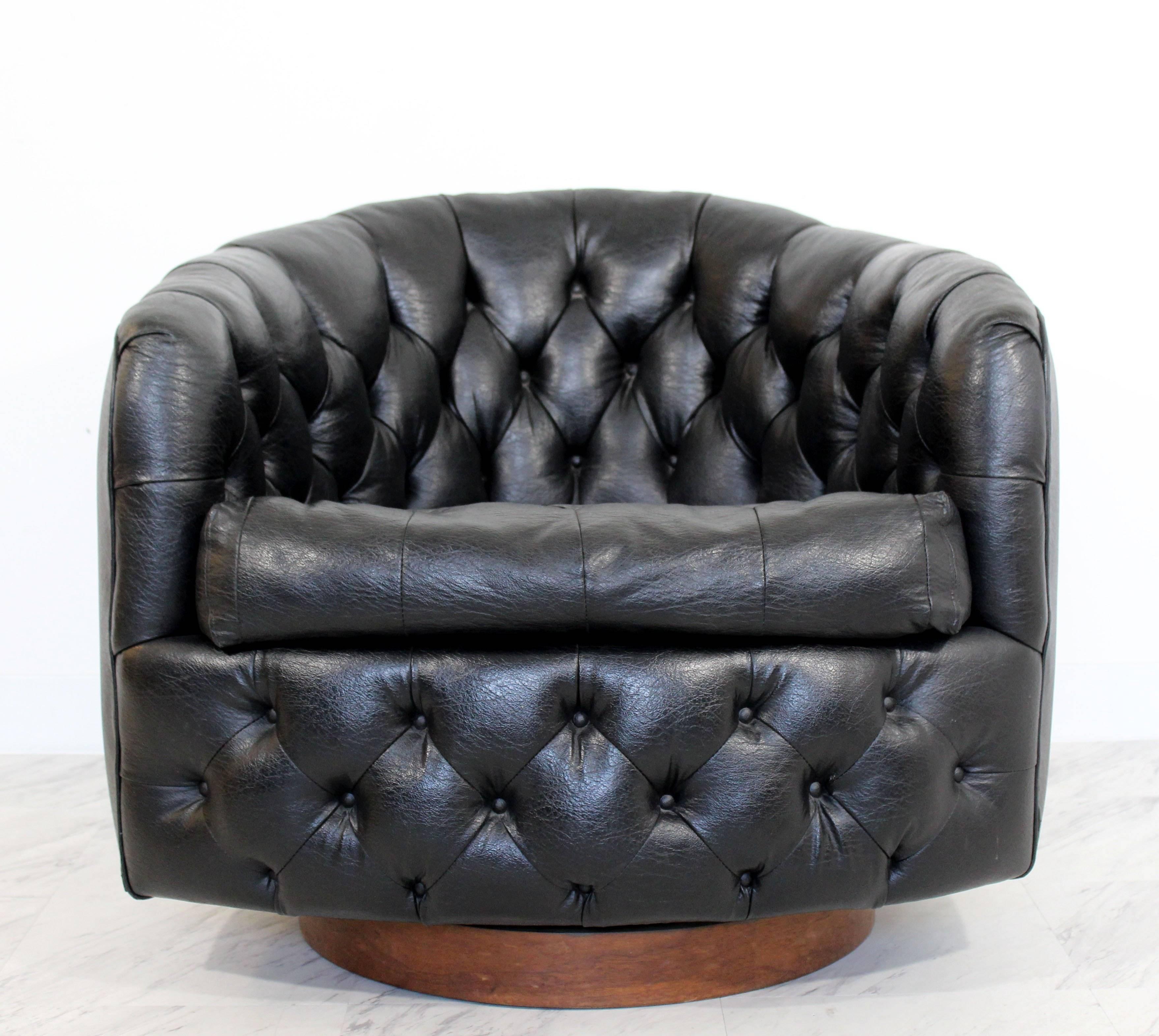 For your consideration is a gorgeous, tufted, black leather, barrel back, swivel lounge chair, on walnut swivel base, by Milo Baughman, circa 1960s. In excellent condition. The dimensions are 30