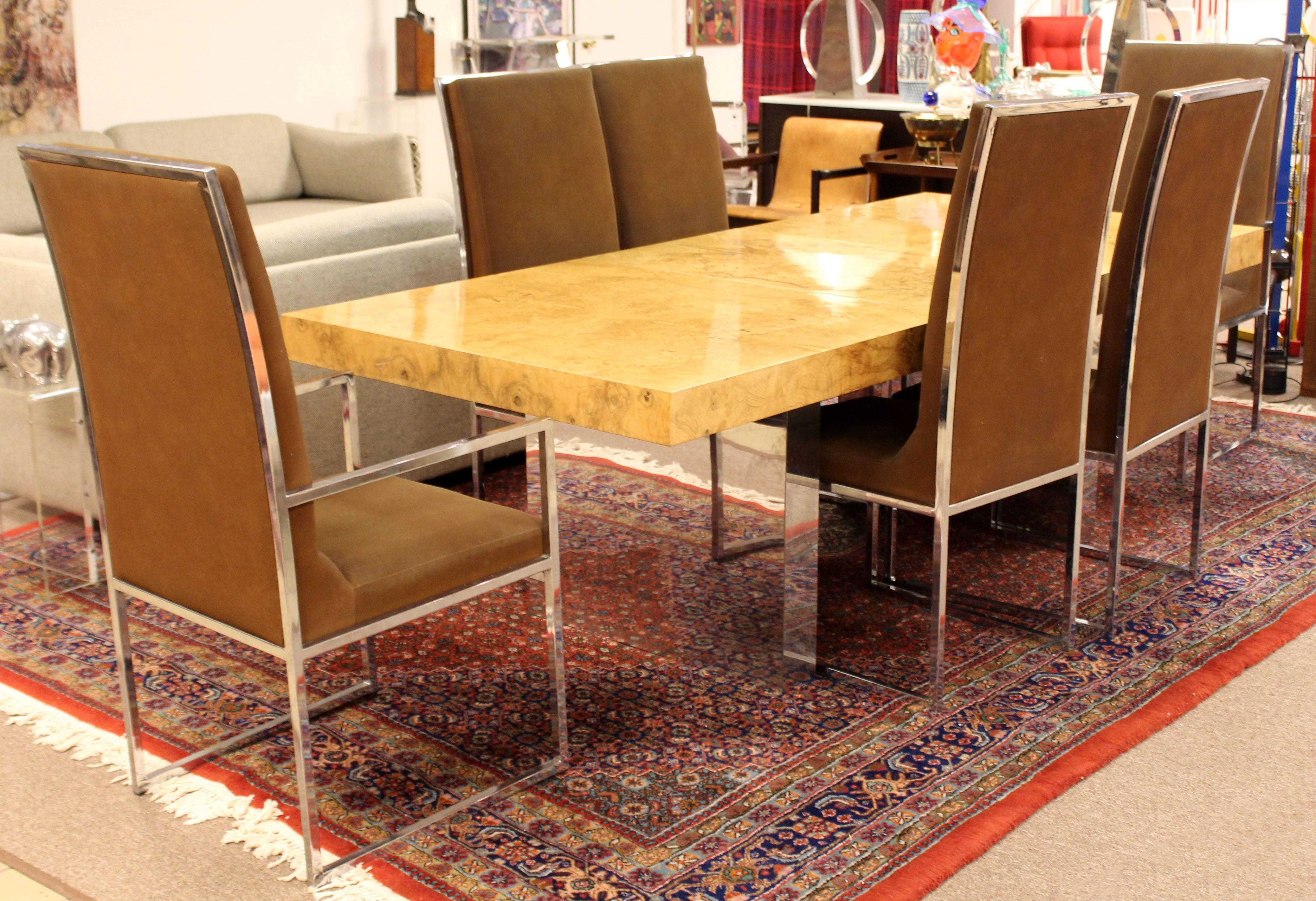 For your consideration is a phenomenal, burl wood dining table, on chrome legs, designed by Milo Baughman, circa the 1970s. Includes two leaves. In very good condition. The dimensions are: With both leafs 110", with no leafs: 66" W x