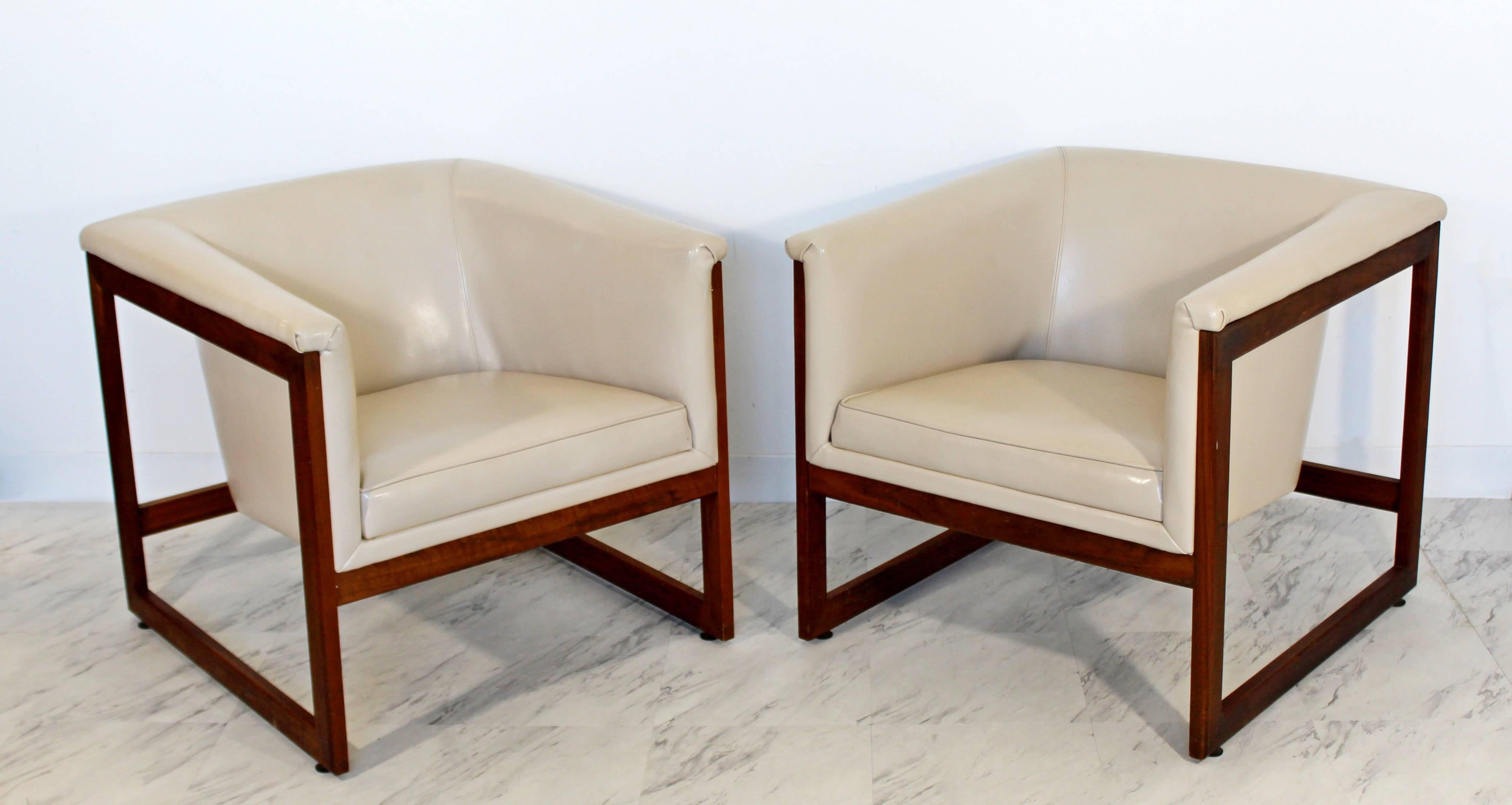 For your consideration is a fantastic pair of rare floating, cube, lounge chairs, made of walnut and cream vinyl, by Milo Baughman, circa 1970s. In excellent condition. The dimensions are 27