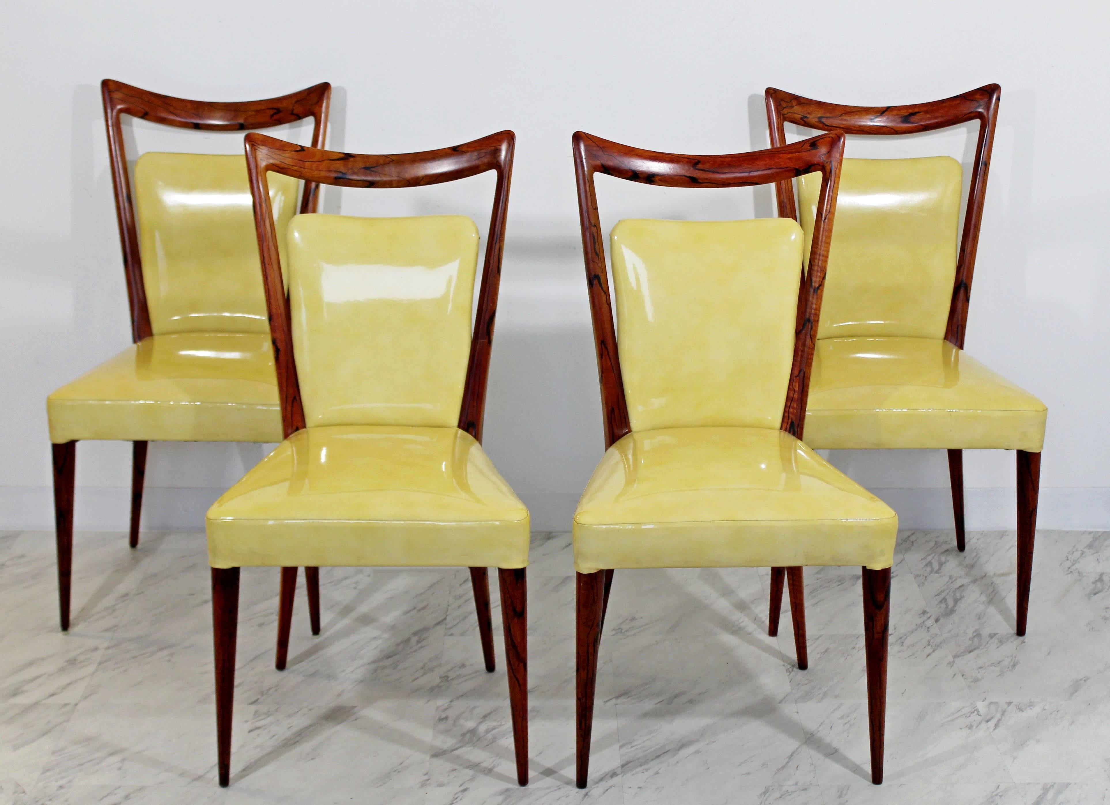 For your consideration is a rare and fabulous, set of four, Italian side dining chairs, made of rosewood and with a high gloss, yellow vinyl upholstery by Melchiorre Bega, circa 1950s.In excellent condition. The dimensions are 19