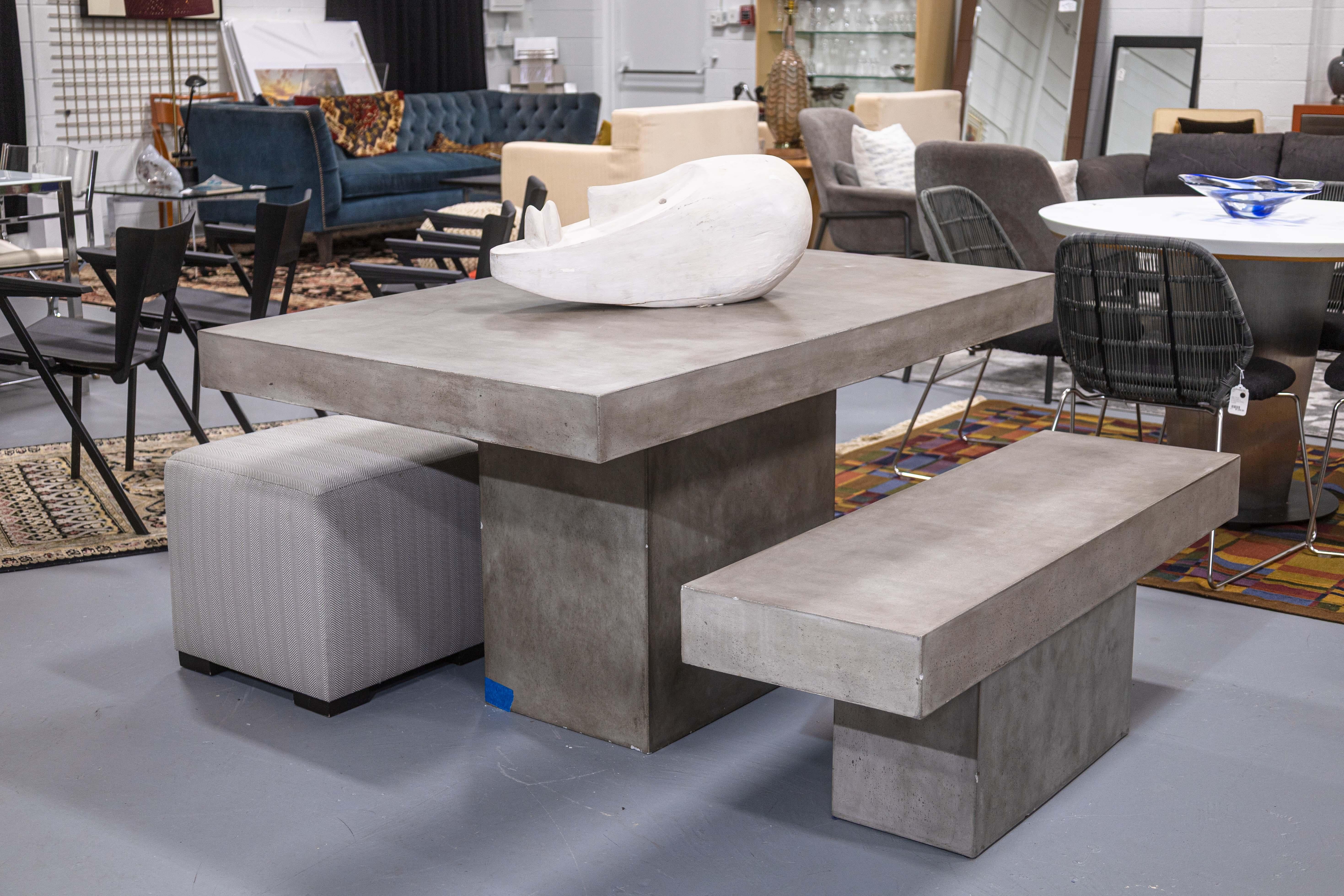 A contemporary modern concrete dinette set. This lovely modern set features a dining table and a matching bench seat. This set is all constructed with a beautiful gray concrete with a semi-gloss finish. This finish lets the concrete have a visually