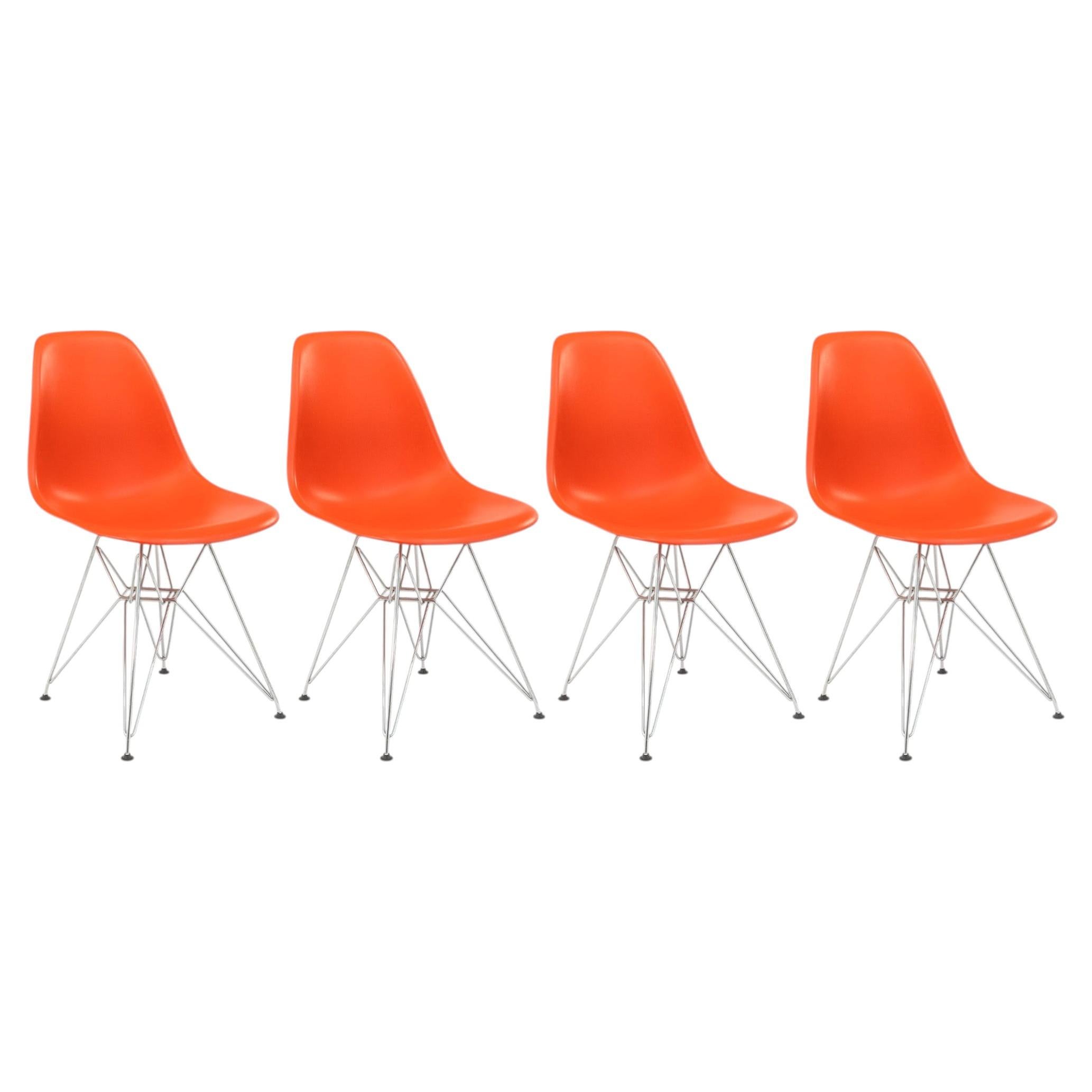 Juego de 4 sillas DSR de Charles y Ray Eames x Vitra, en color naranja oxidado y con base tipo Torre Eiffel