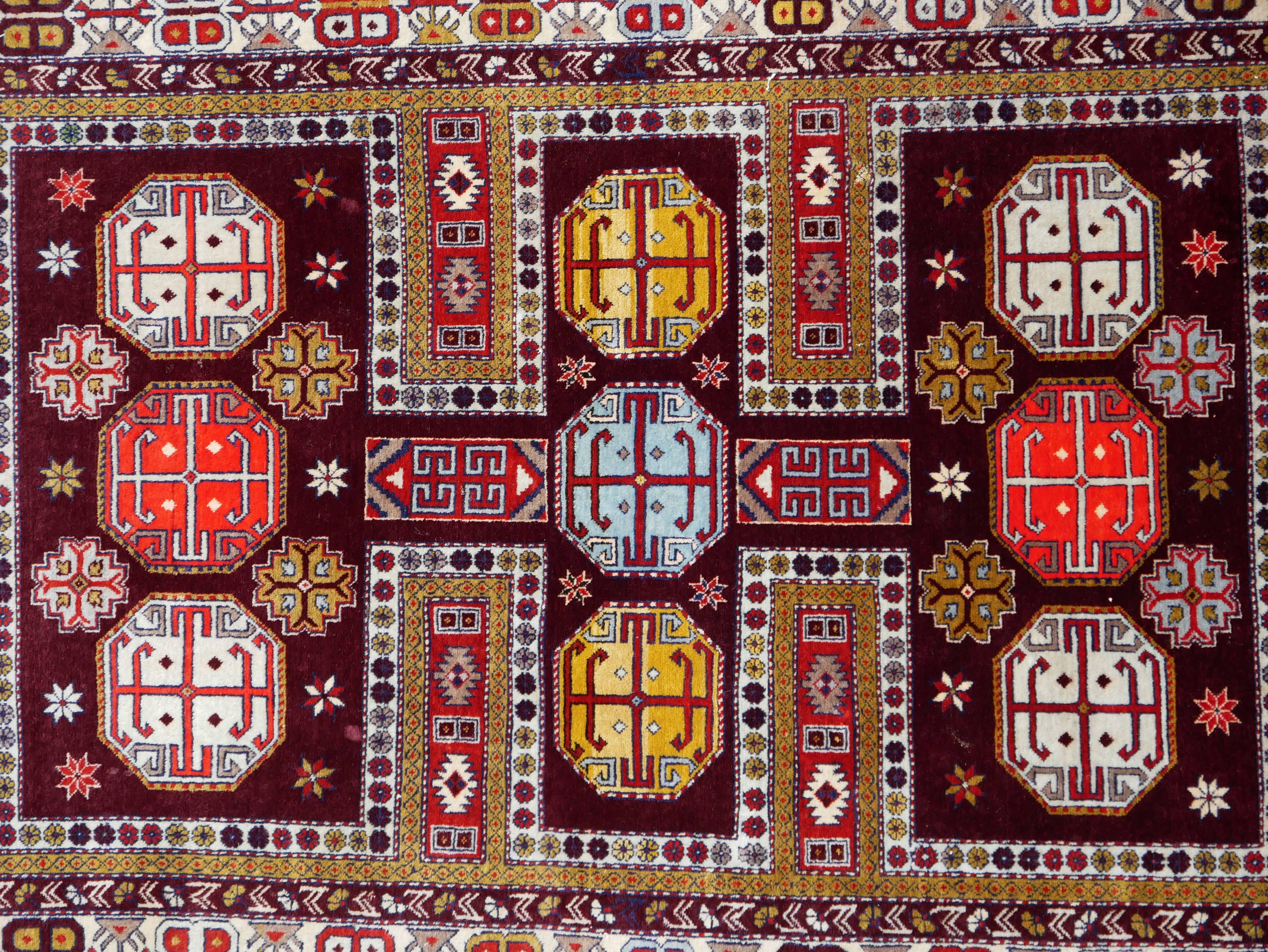 This is an early 20th century Caucasian rug from the town of Derbent on the shores of the Caspian Sea in Russia.
It features an array of multi-color geometric figures set in a deep, aged burgundy field. 
 
Dimensions: c. 140 x 200 cm or c. 4.6 x