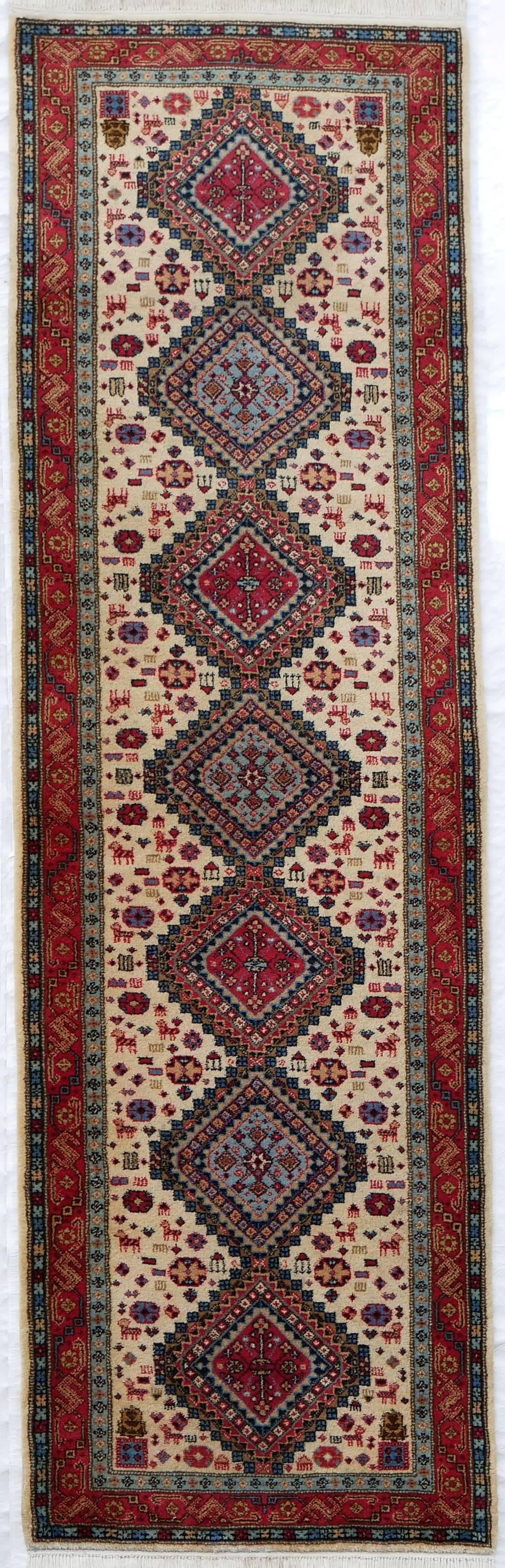 This is a rare Tabriz atelier runner featuring a number of nomadic motif in tribute to the weaving arts tribal heritage. 
The seven-medallion lozenge (Yalameh) is set against a cream field replete with animal symbols (Afshari). 

Origin: