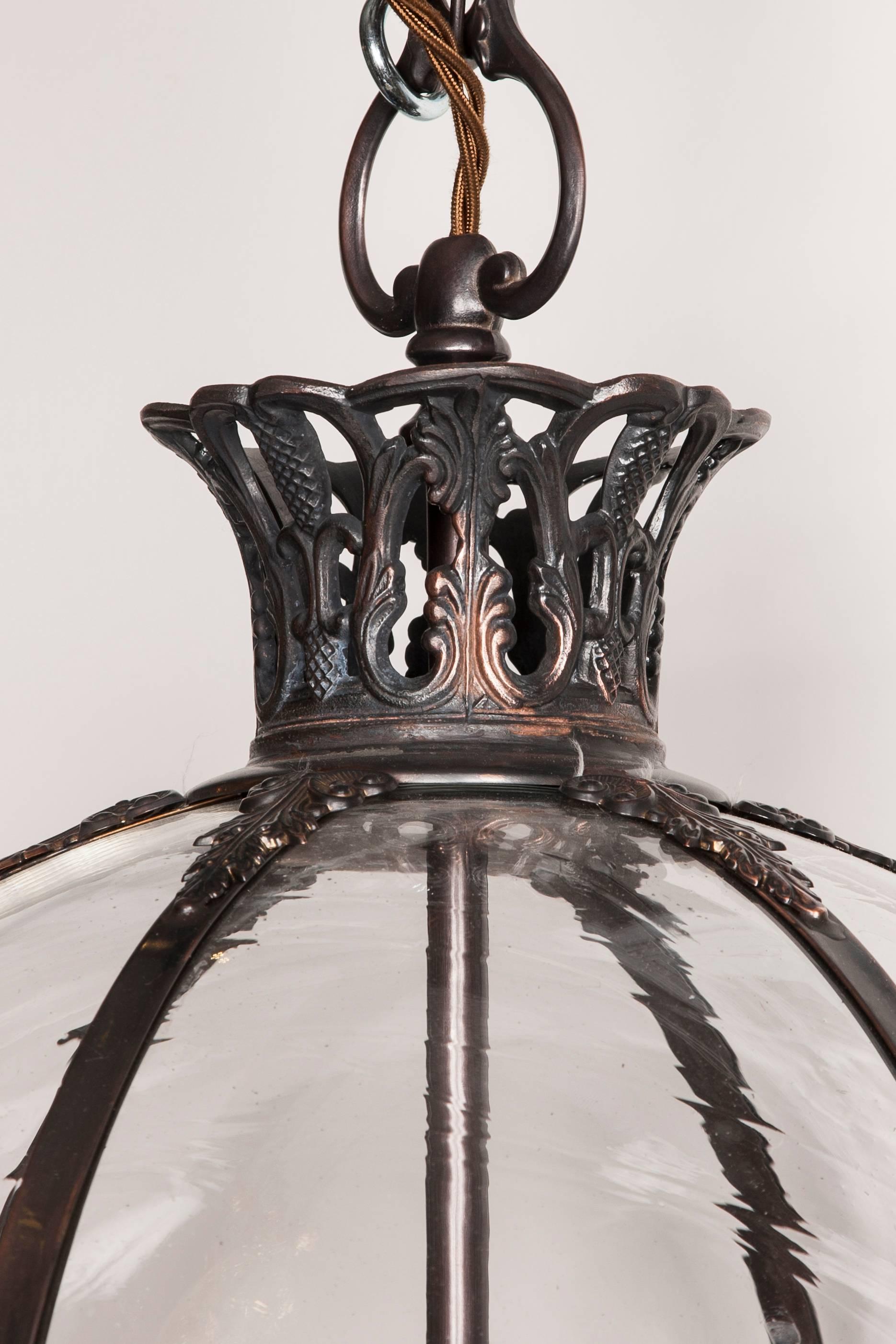 Superb quality, handmade three light antique bronze globe lantern with handblown arched glass segments and Fleur De-Lys motif.
